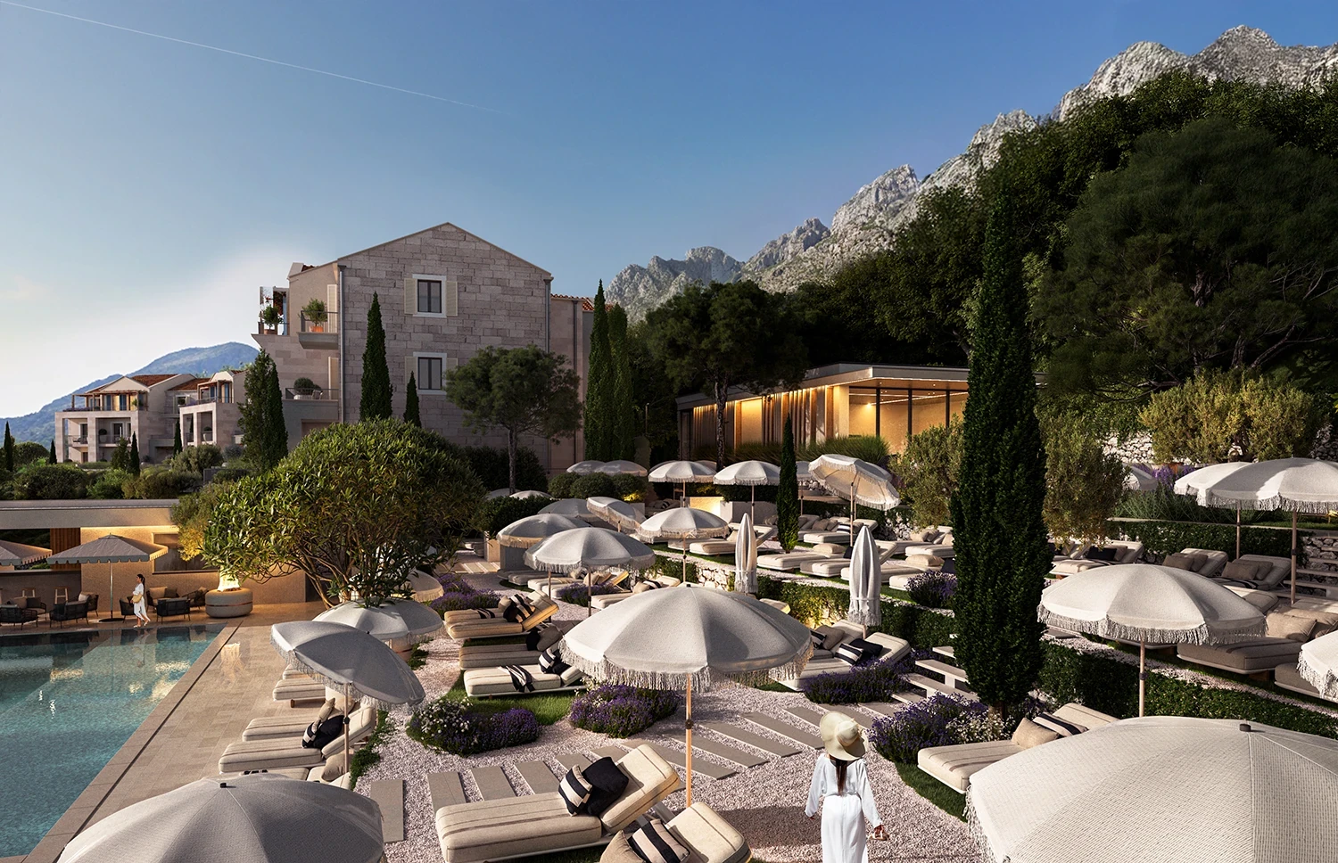 Luxury poolside terrace at the Olive Grove residences, featuring sunbeds, parasols, landscaped greenery, and modern Mediterranean architecture set against mountain views.