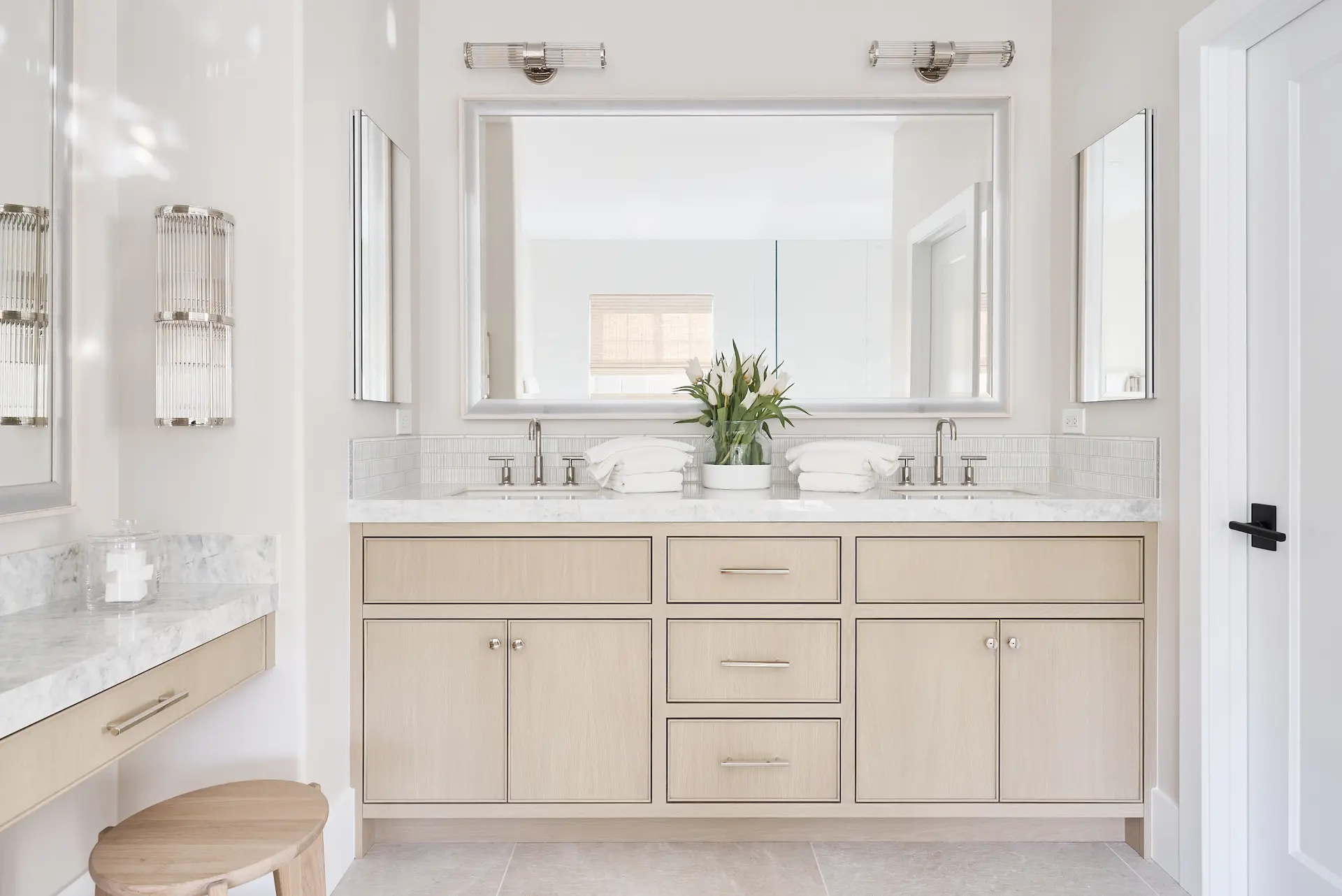 View of the double vanity in the primary bathroom, featuring mirrors, sinks, and storage in the Irvine Contemporary Coastal Remodel. Photo by Todd Huge.