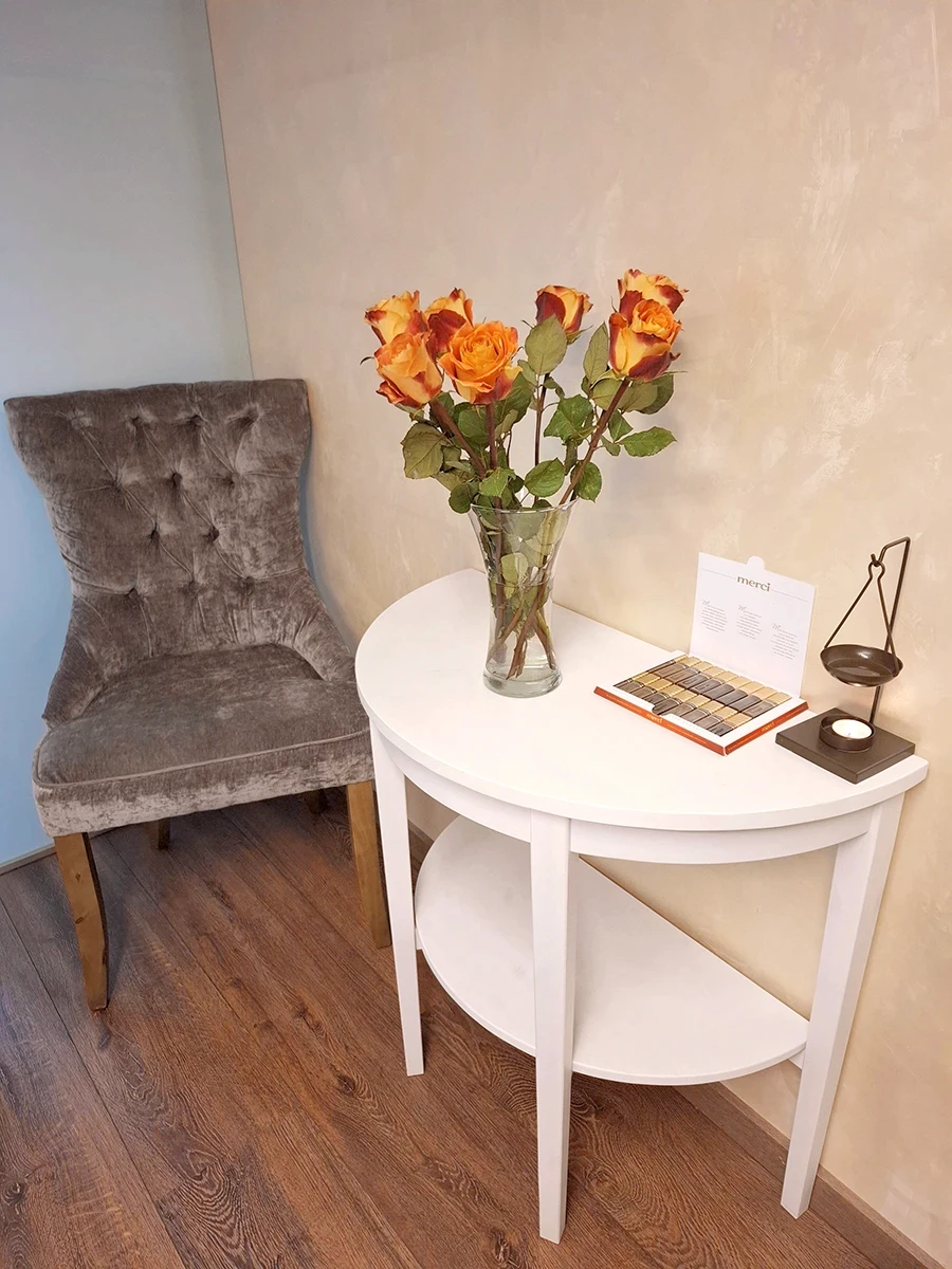 Kosmetoloģijas kabineta interjers ar krēslu un galdiņu