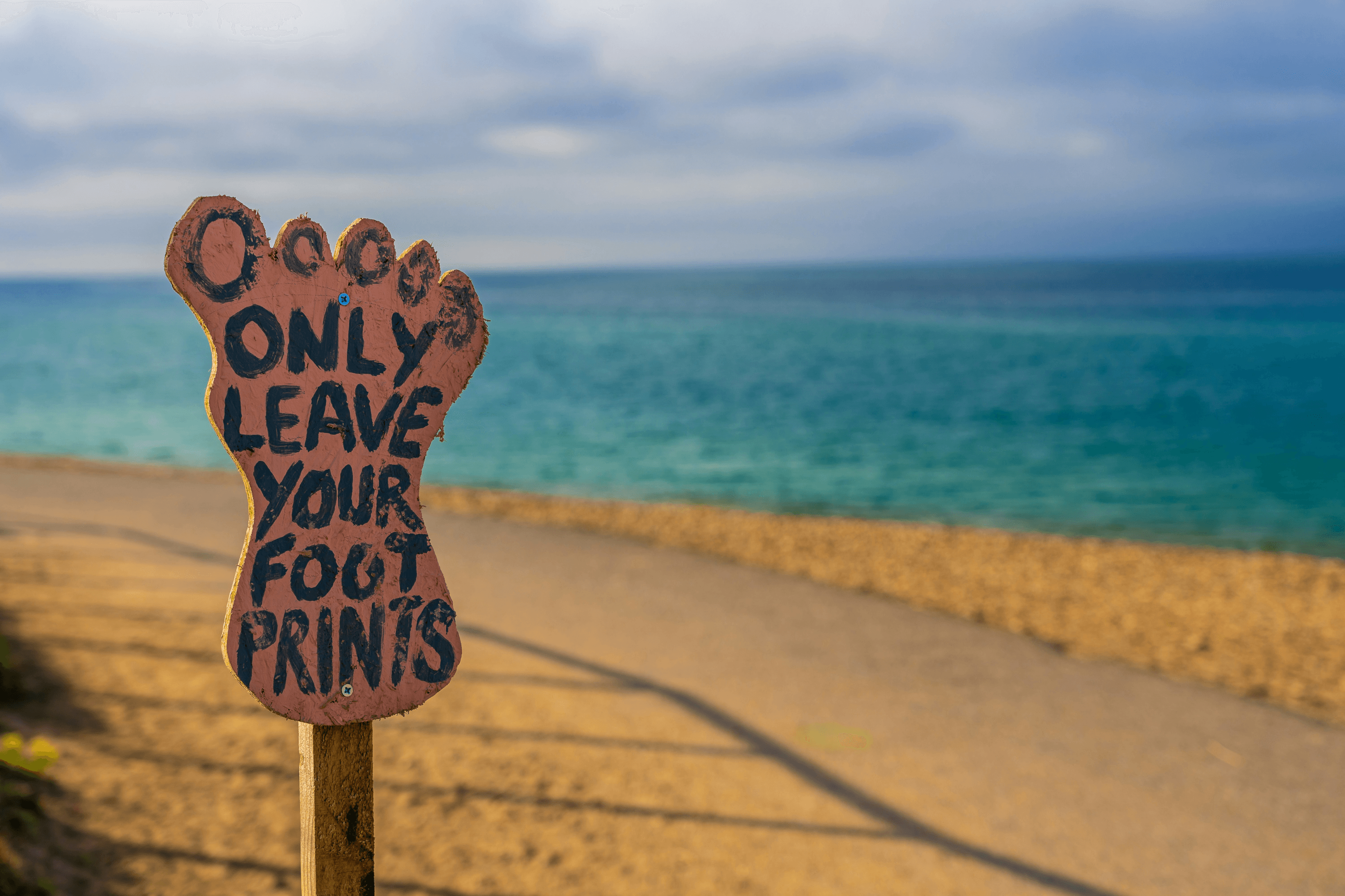Wooden footprint that says "Only leave your footprints"