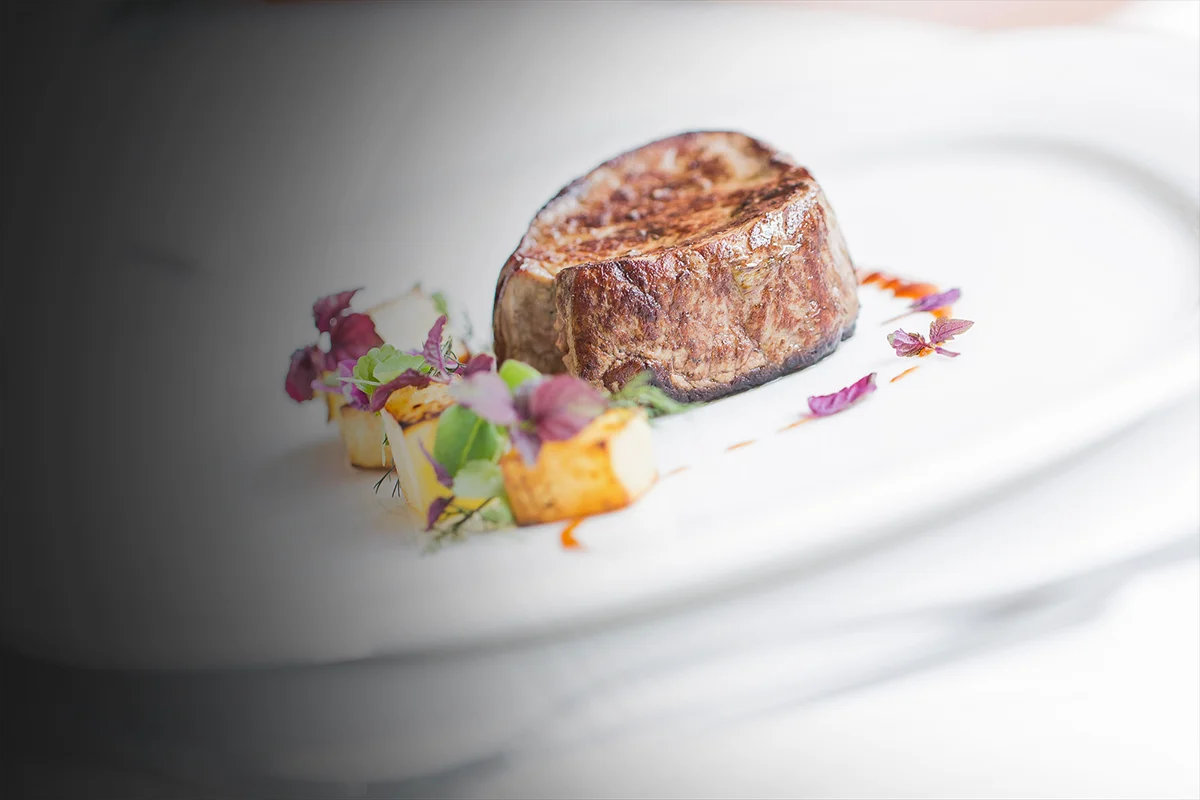 A dimly lit table set with assorted dishes, candles, and an atmospheric smoke, creating a mysterious vibe.