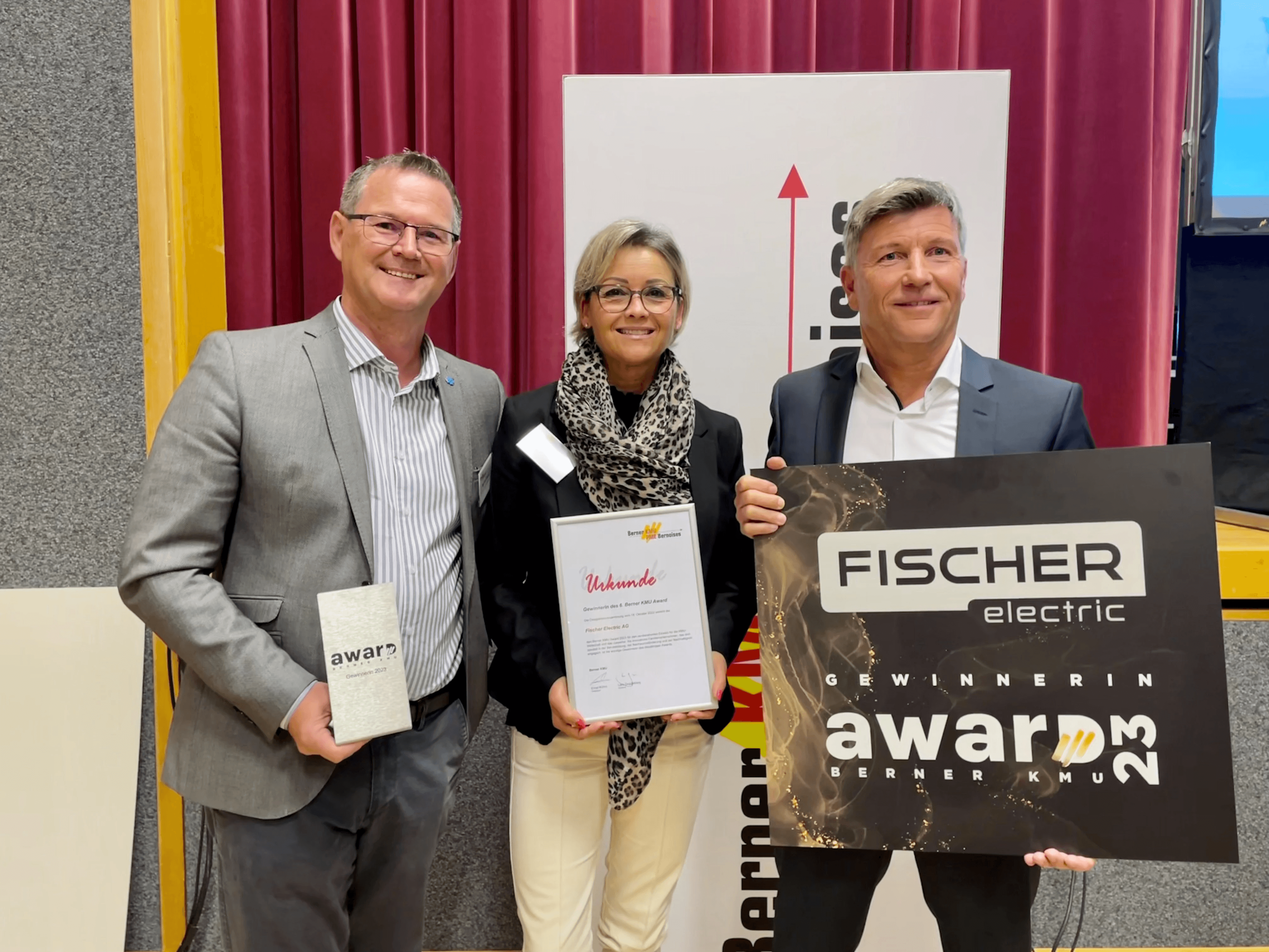 Manfred Ulmann, Sabine Minder-Fischer und Hans-Ruedi Minder mit Urkunde, Trophäe und Gewinner-Tafel des Berner KMU Award