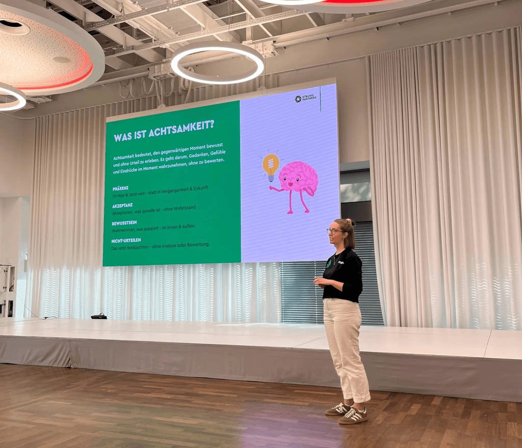 Isabel Voß auf einer Bühne mit einer Präsentation zum Thema mentale Gesundheit
