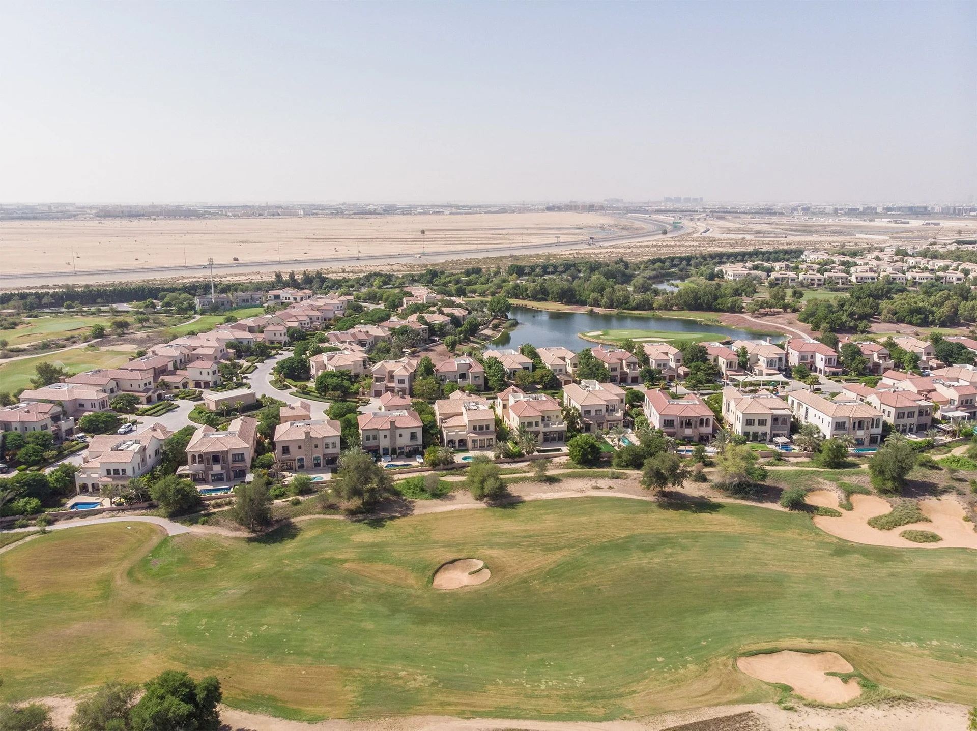 Overhead perspective of Jumeirah Golf Estates, highlighting the cityscape and Redwood Park below.