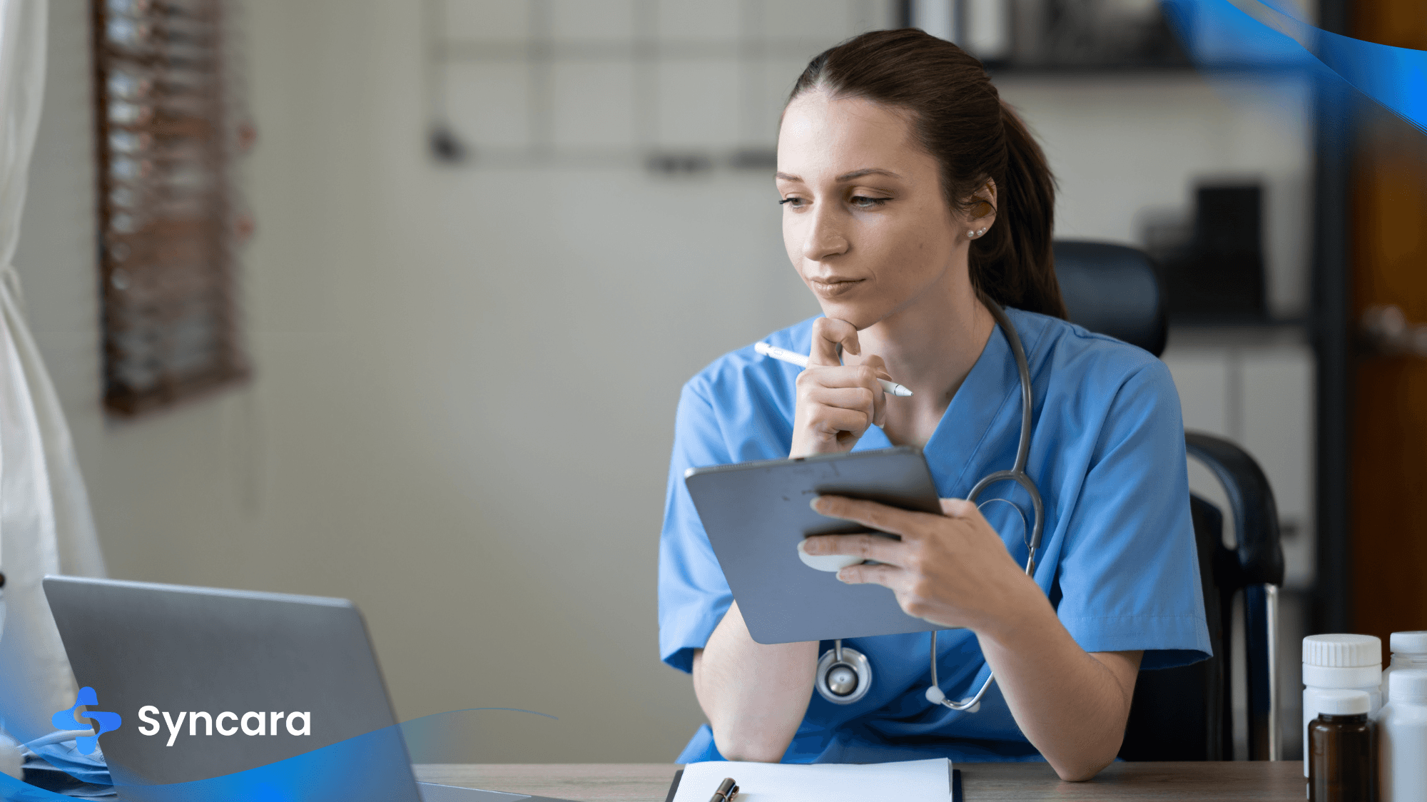 Nurse in scrubs reading a Canadian healthcare newsletter on a laptop.