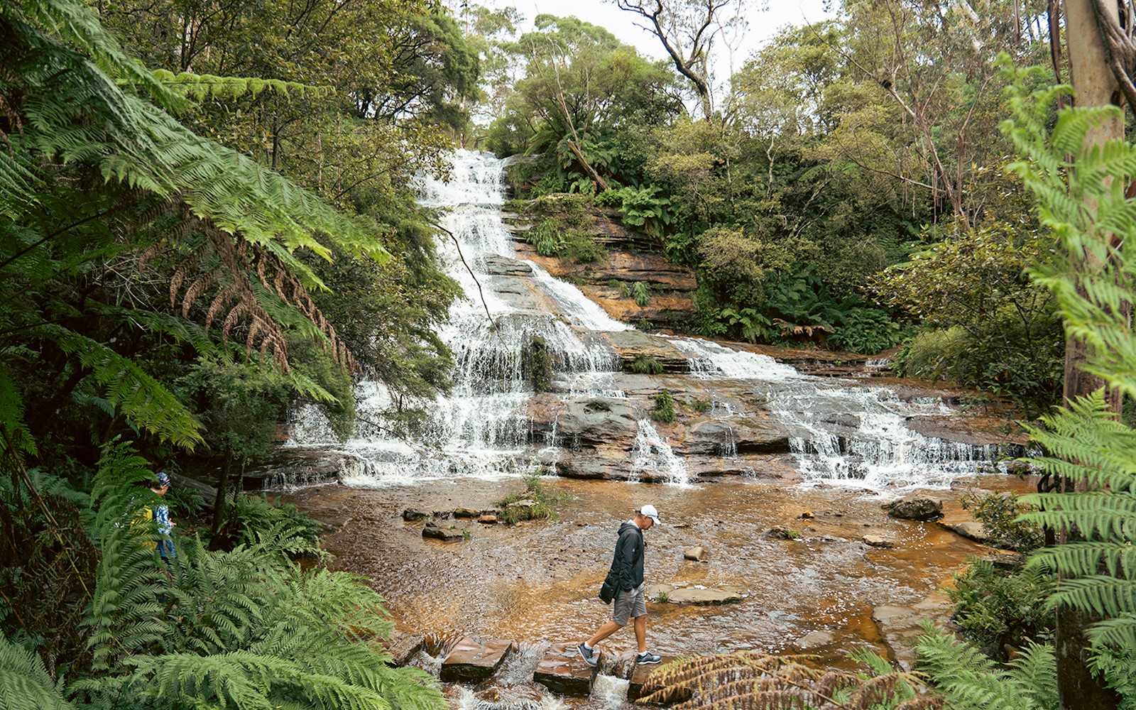 Man walking near Katoomba Cascades waterfalls in Blue Mountains, Australia.