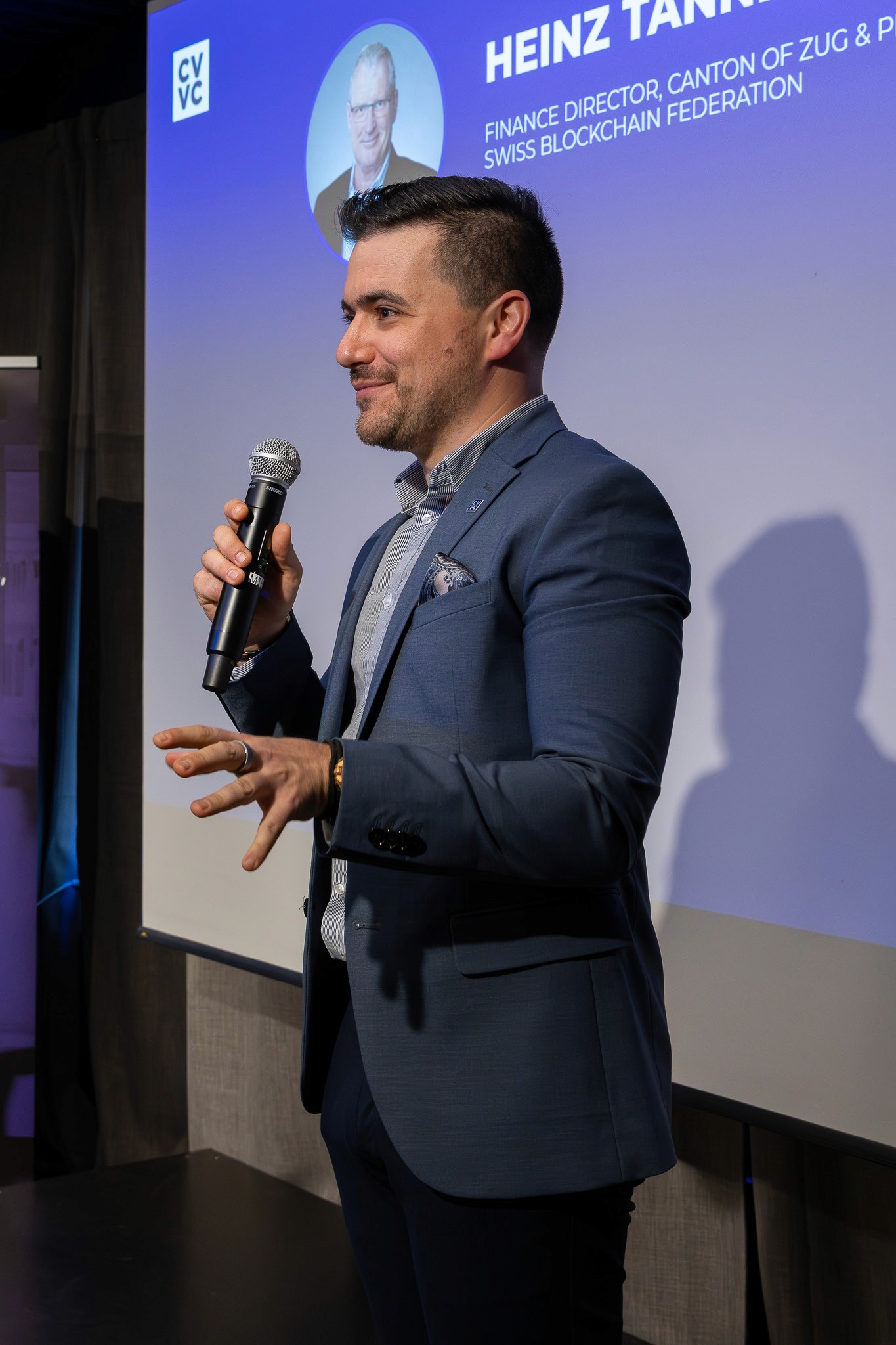 Speaker presenting on stage during a conference session in Zug.