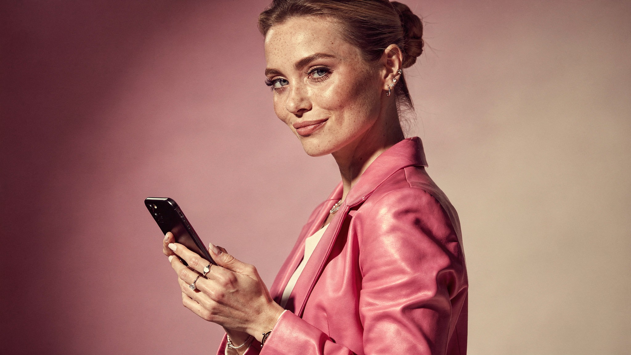 Creator with a wry knowing expression holding her phone