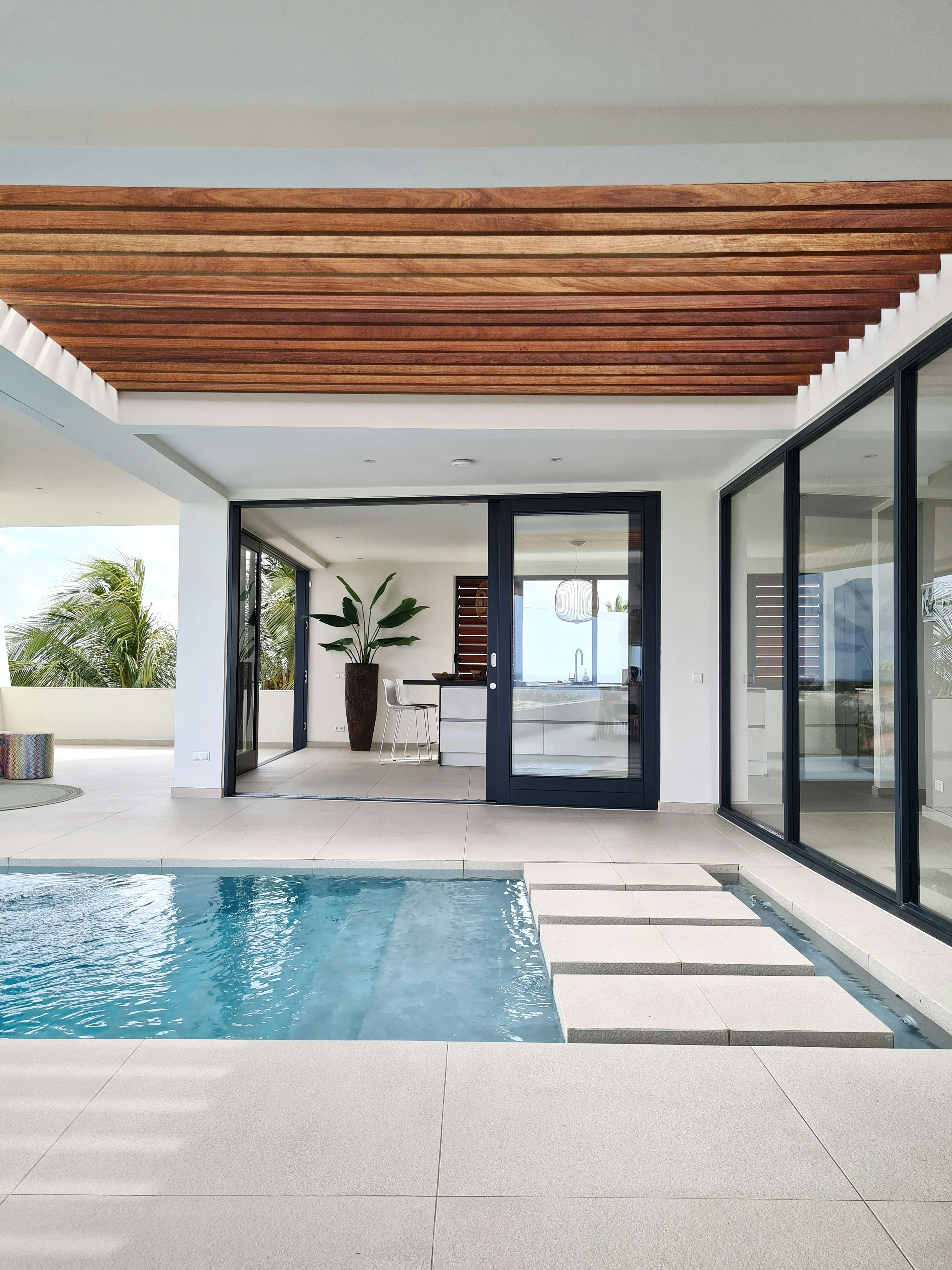 a swimming pool with a wooden ceiling and sliding glass doors