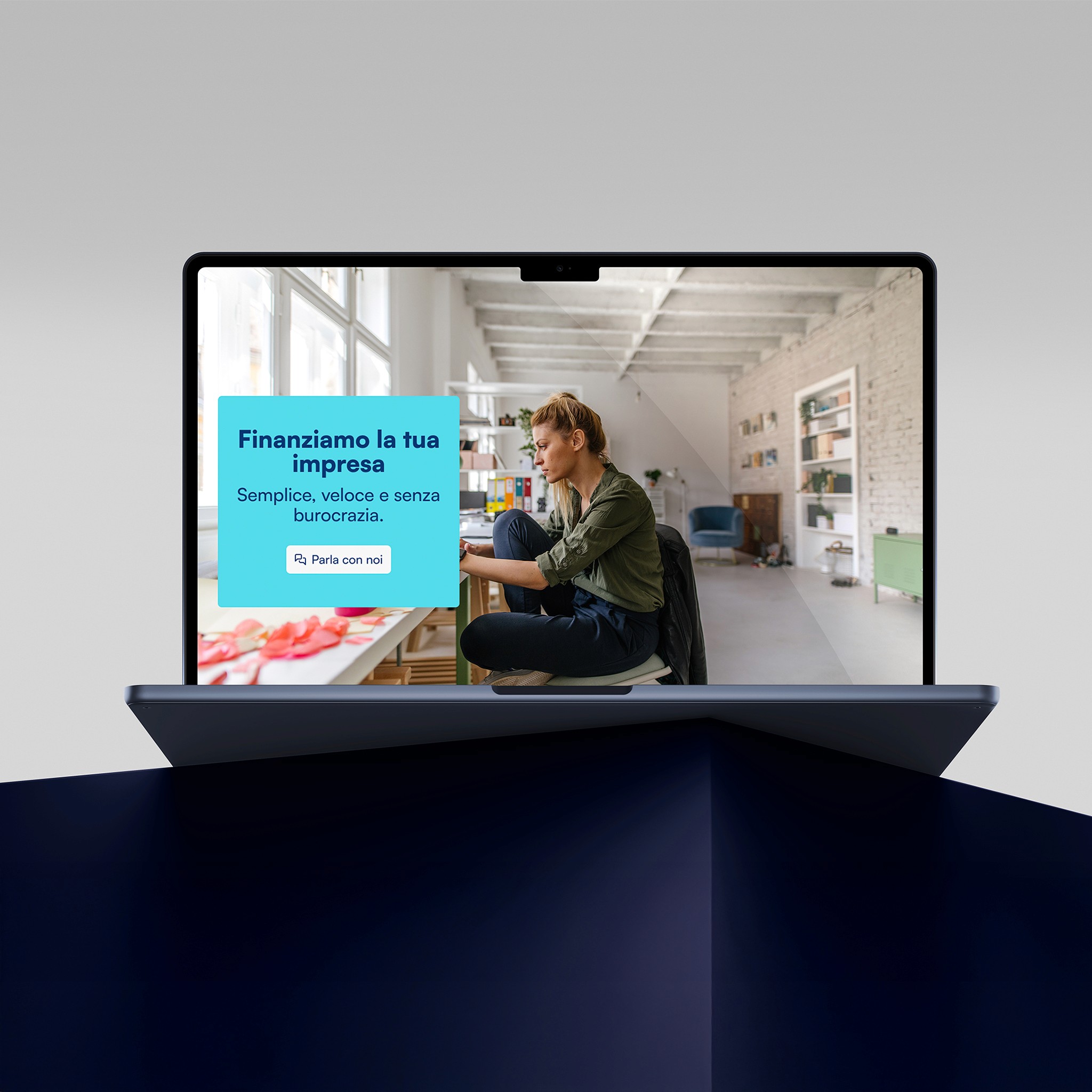 Un laptop su una superficie scura mostrando il nuovo sito Finpromoter. Si vede una donna che lavora in un luminoso ufficio a casa. Il messaggio di Finpromoter dice “Finanziamo la tua impresa. Semplice, veloce e senza burocrazia" seguito da un pulsante etichettato “Parla con noi”.