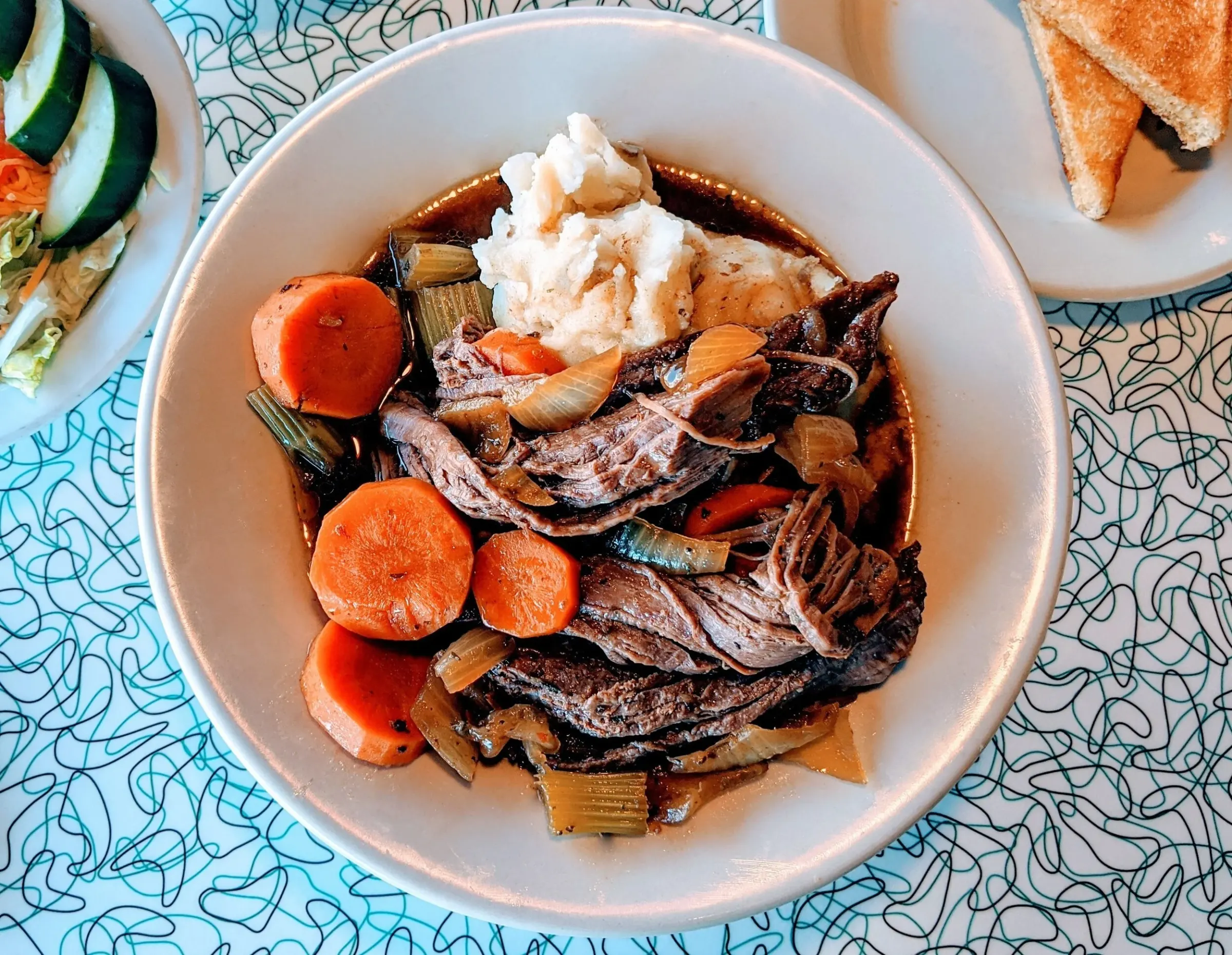 Pot roast dinner with carrots over mashed potatoes