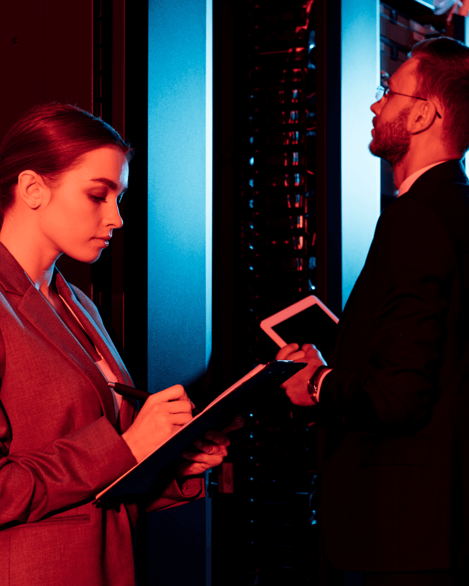 A man and a woman working in a server room 