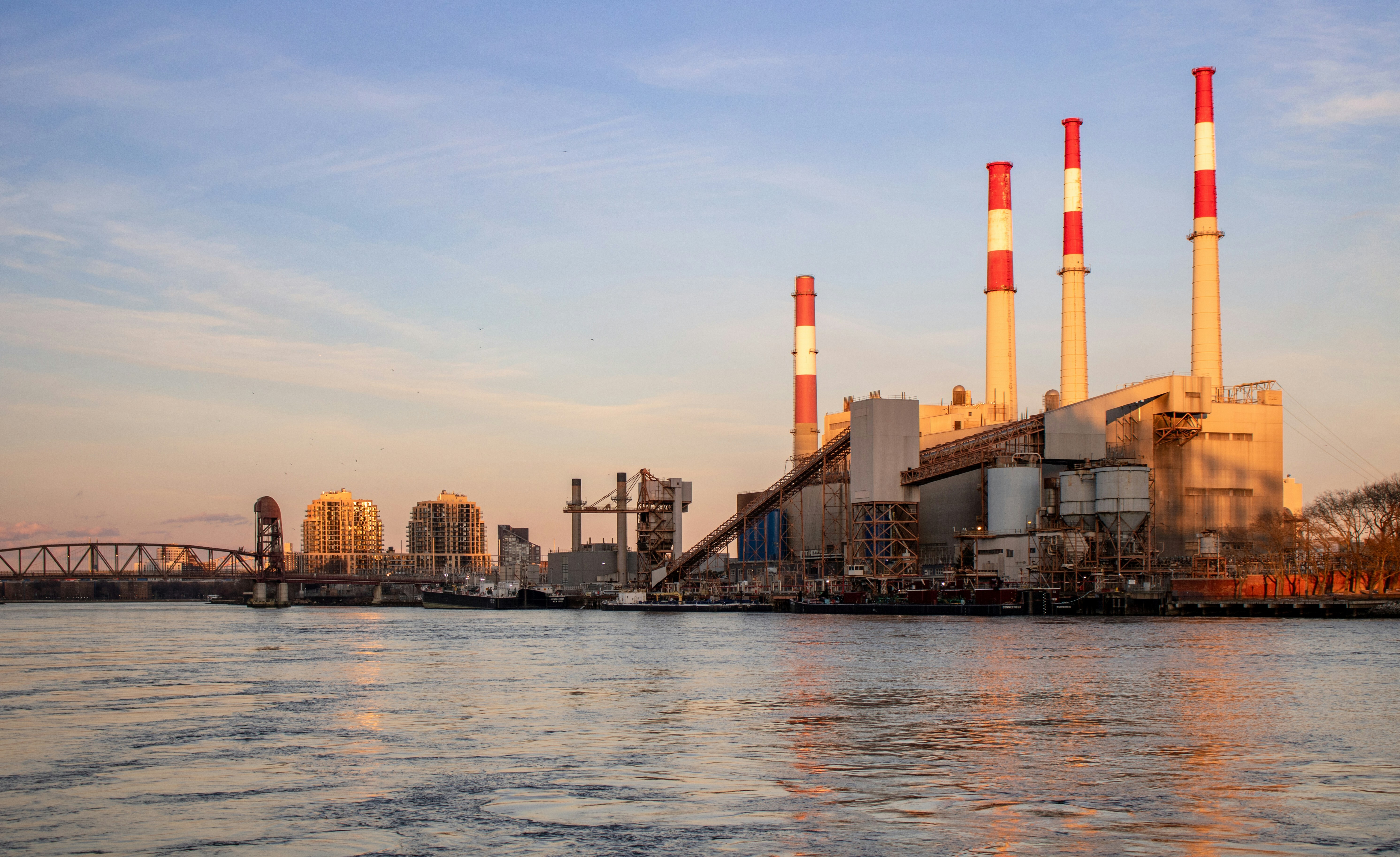 Industrial plant with smokestacks beside a river