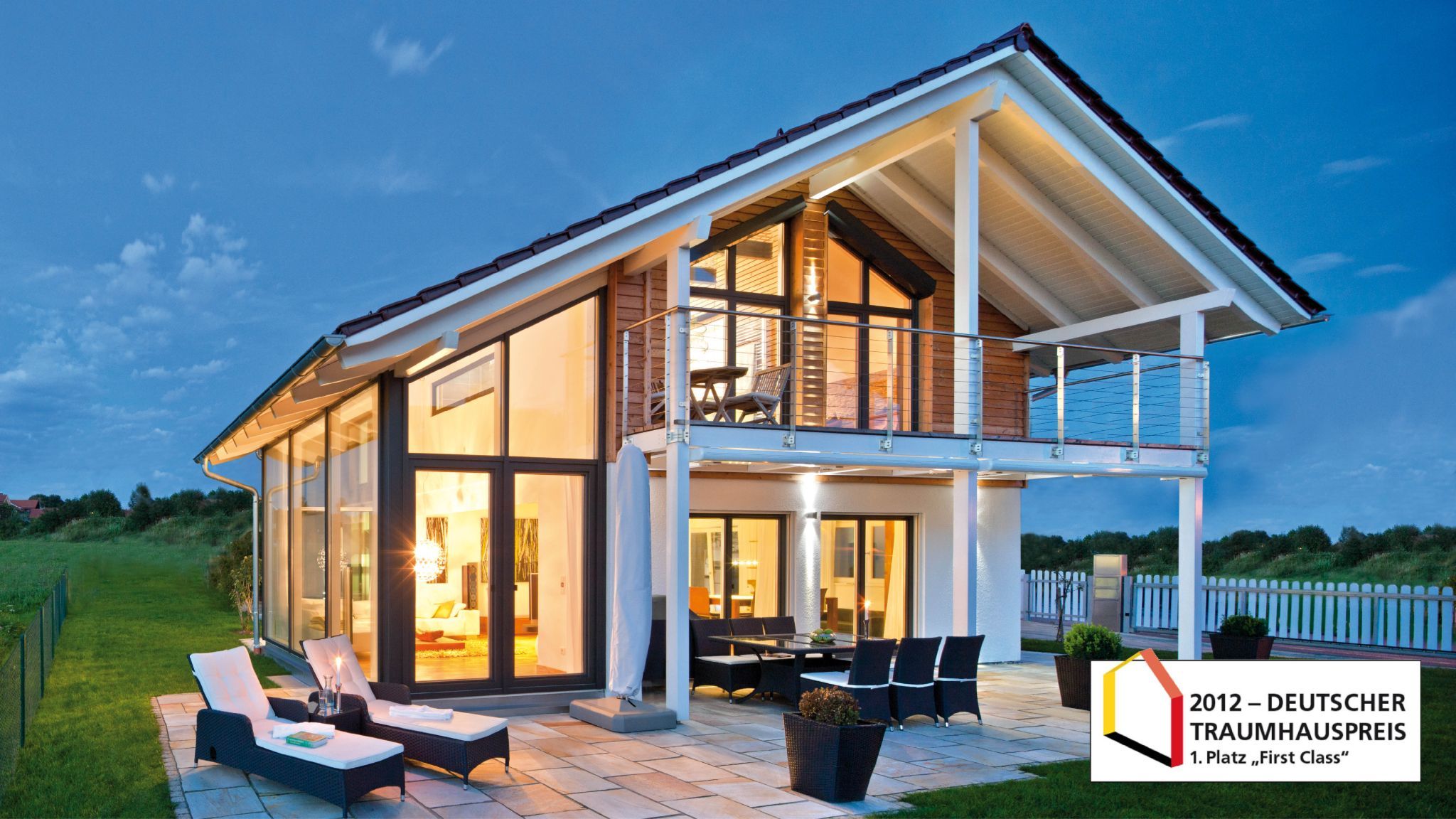 Moderne Villa mit viel Glas und Balkon, Terrasse mit Liegestühlen und Esstisch, mit Auszeichnung "Deutscher Traumhauspreis 2012".