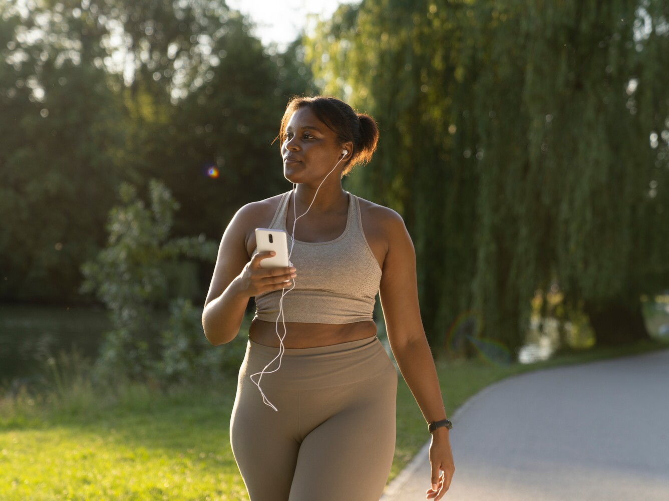 woman doing a gentle walk in a park to show how many steps per day to lose weight for a woman without hitting 10,000