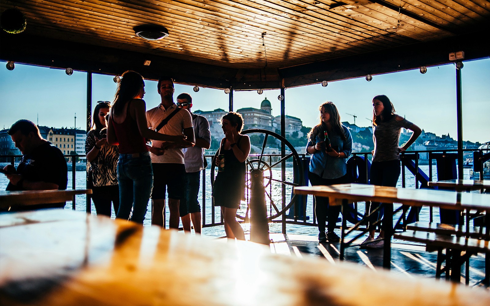 Gruppe genießt eine Donau-Kreuzfahrt mit der Skyline von Budapest im Hintergrund.