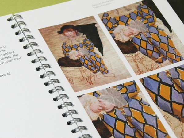 The image shows a page from a spiral-bound book featuring four photographs arranged in a grid. The top left photograph depicts a young girl in a blue and yellow checkered dress with a white collar, seated on a chair. The top right photograph shows the same girl, also in a blue and yellow checkered dress, with a white collar, seated in a similar chair. The bottom left photograph focuses on the girl’s face, capturing a close-up of her features. The bottom right photograph presents a close-up of her face and a blue and yellow checkered fabric draped over her shoulders and upper body. The background of the page is white, and the text on the page is partially visible but not fully legible.