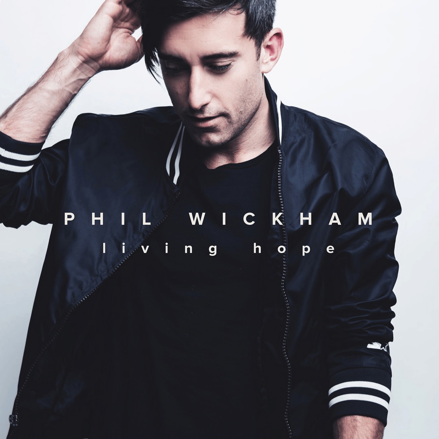 Album artwork for "Living Hope" by Phil Wickham shows a man in a black jacket looking down, hand in hair. Text: Phil Wickham living hope.