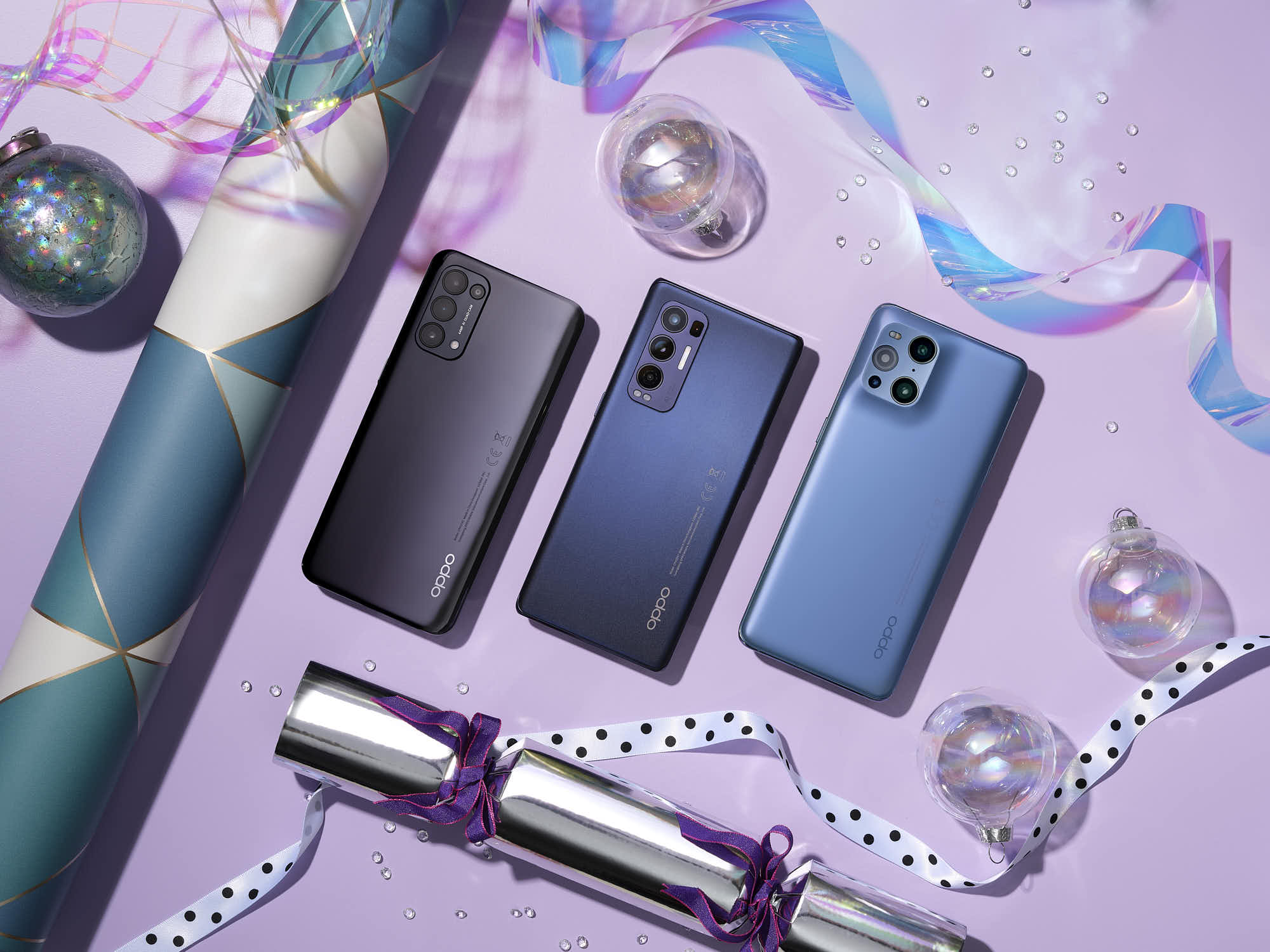 Three Oppo smartphones on a decorative holiday-themed background.