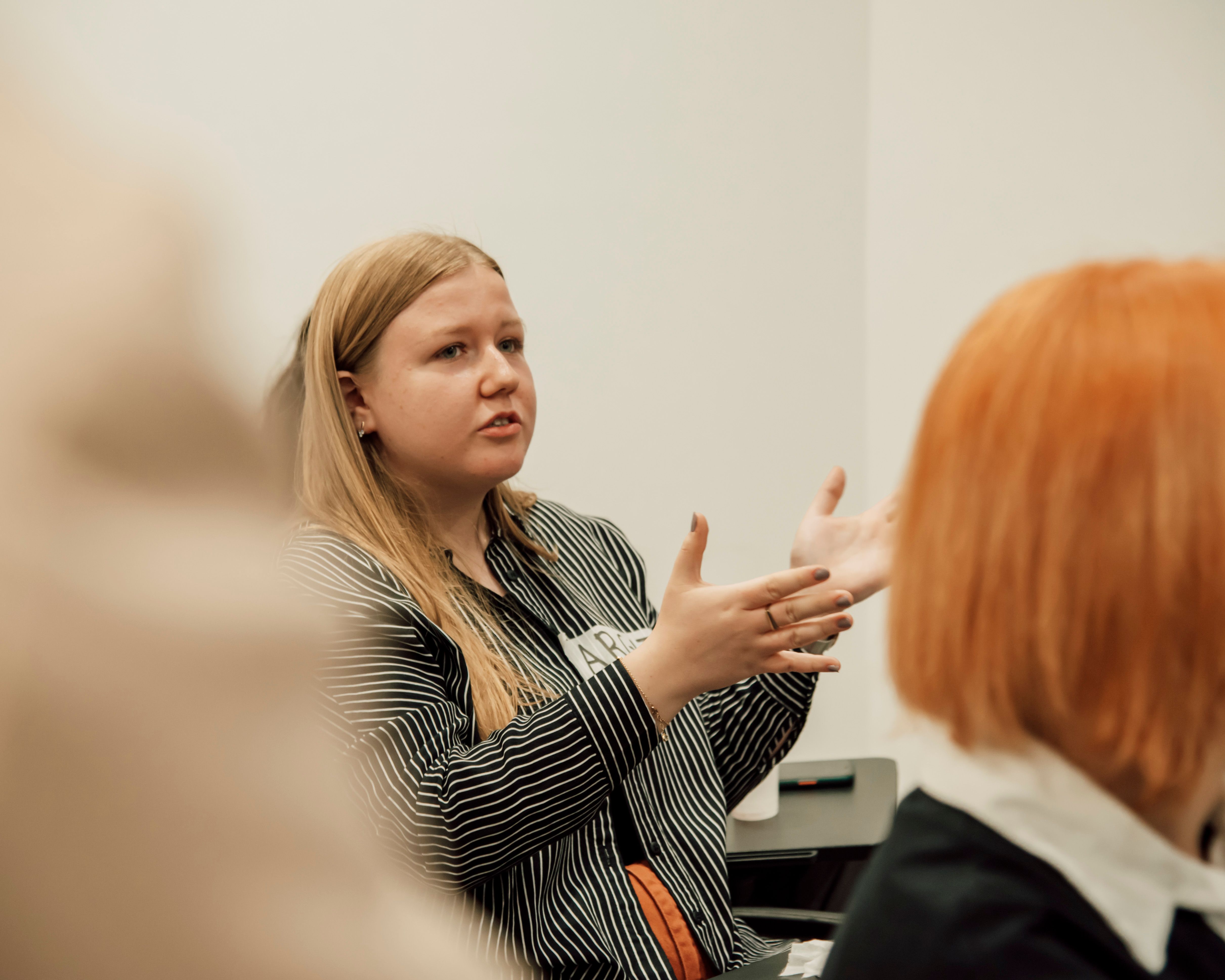 woman-with-long-blonde-hair-speaking-passionately-during-a-group-meeting-indoors - xhemi-photo (pexels)