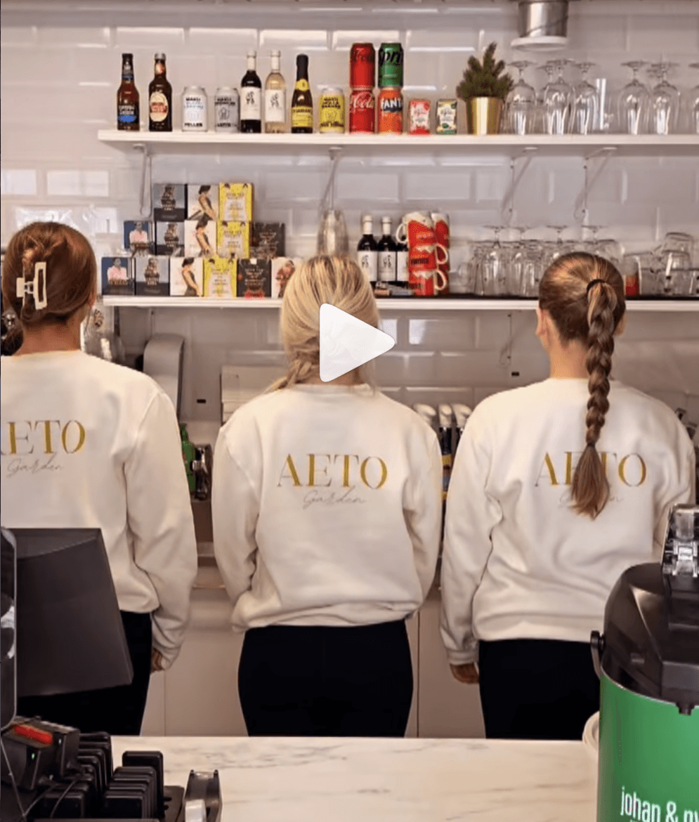 Aeto Gardenin baristit työssään AETO-collegepaidoissa kahvilan tiskillä