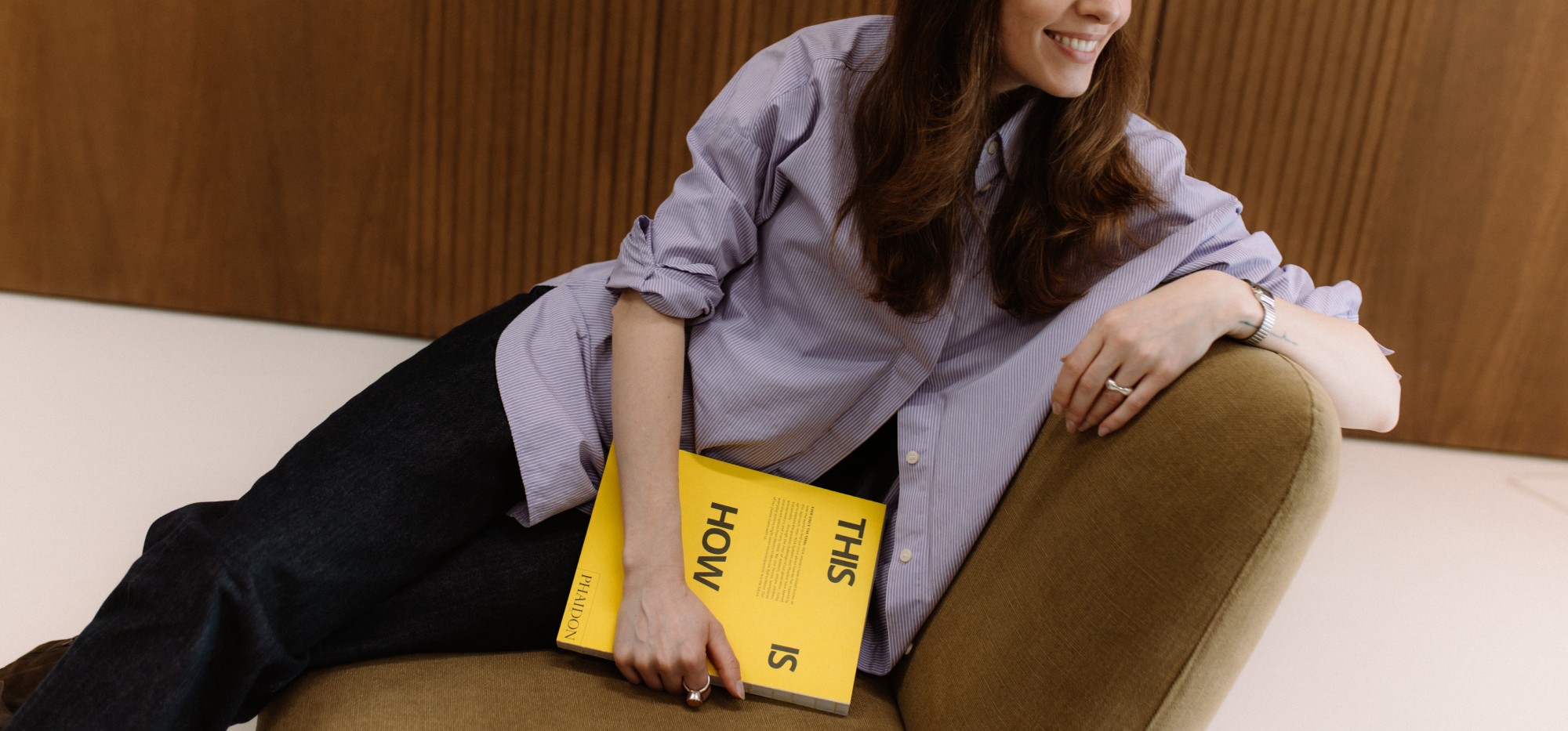 woman sitting while working on laptop and smiling 