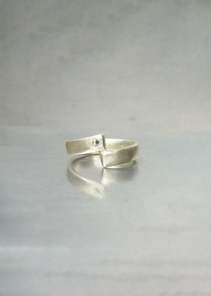 Silver ring on a light gray background