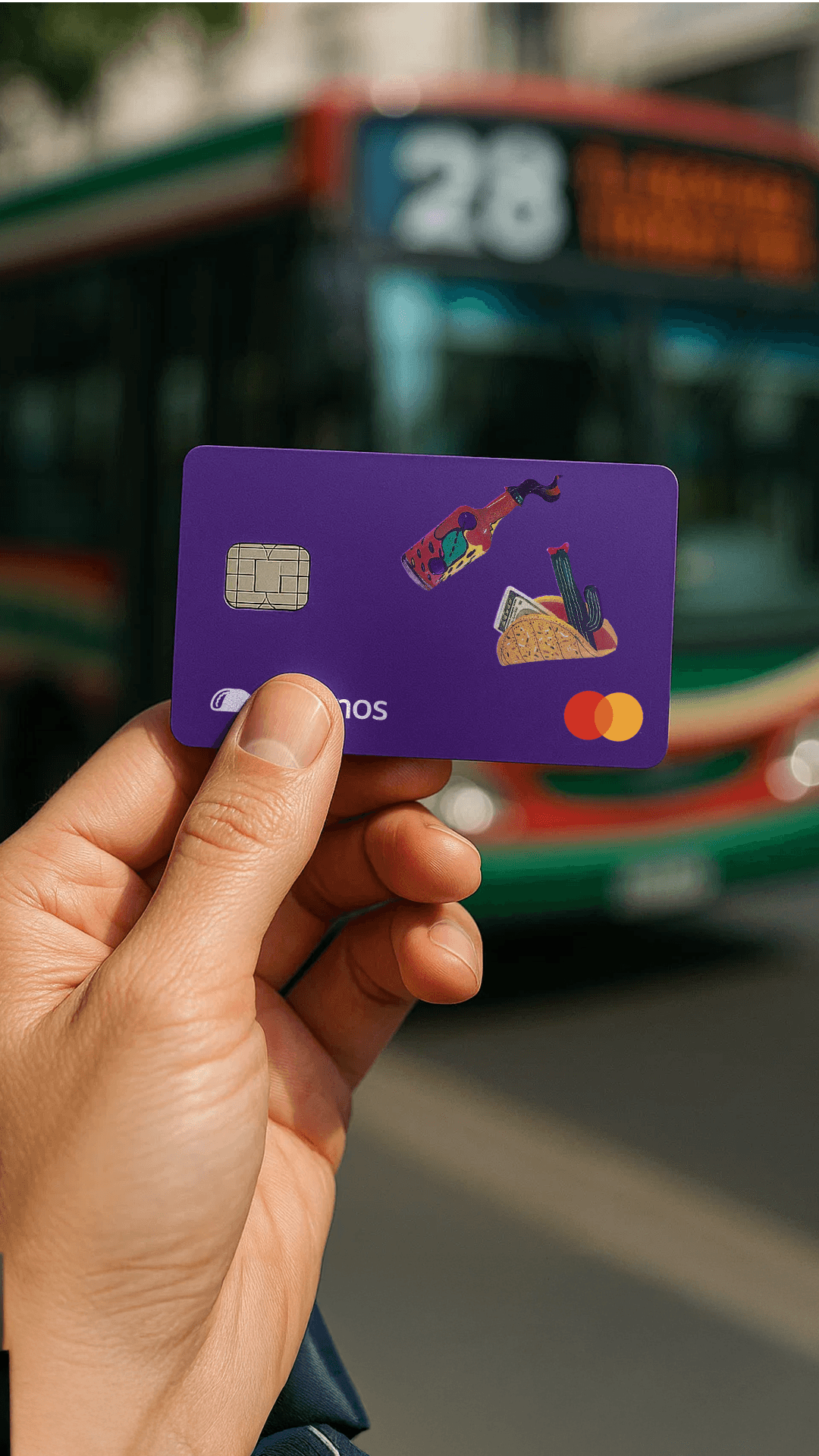 Primer plano de una mano sosteniendo la tarjeta física de Takenos, de color violeta con ilustraciones de un taco y una botella, frente a un colectivo de la línea 28 en Buenos Aires. Esta tarjeta es una herramienta clave para quienes buscan cómo recibir euros de España en Argentina y gestionar sus fondos de manera global.
