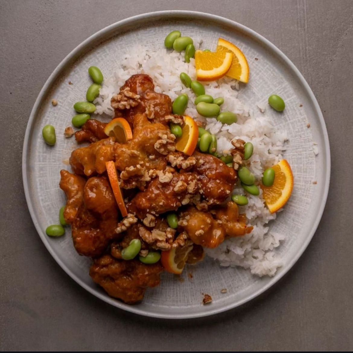 Young woman with short, dark hair and a yellow sweater looks serious, surrounded by hands holding smartphones, conveying intrusion and tension.