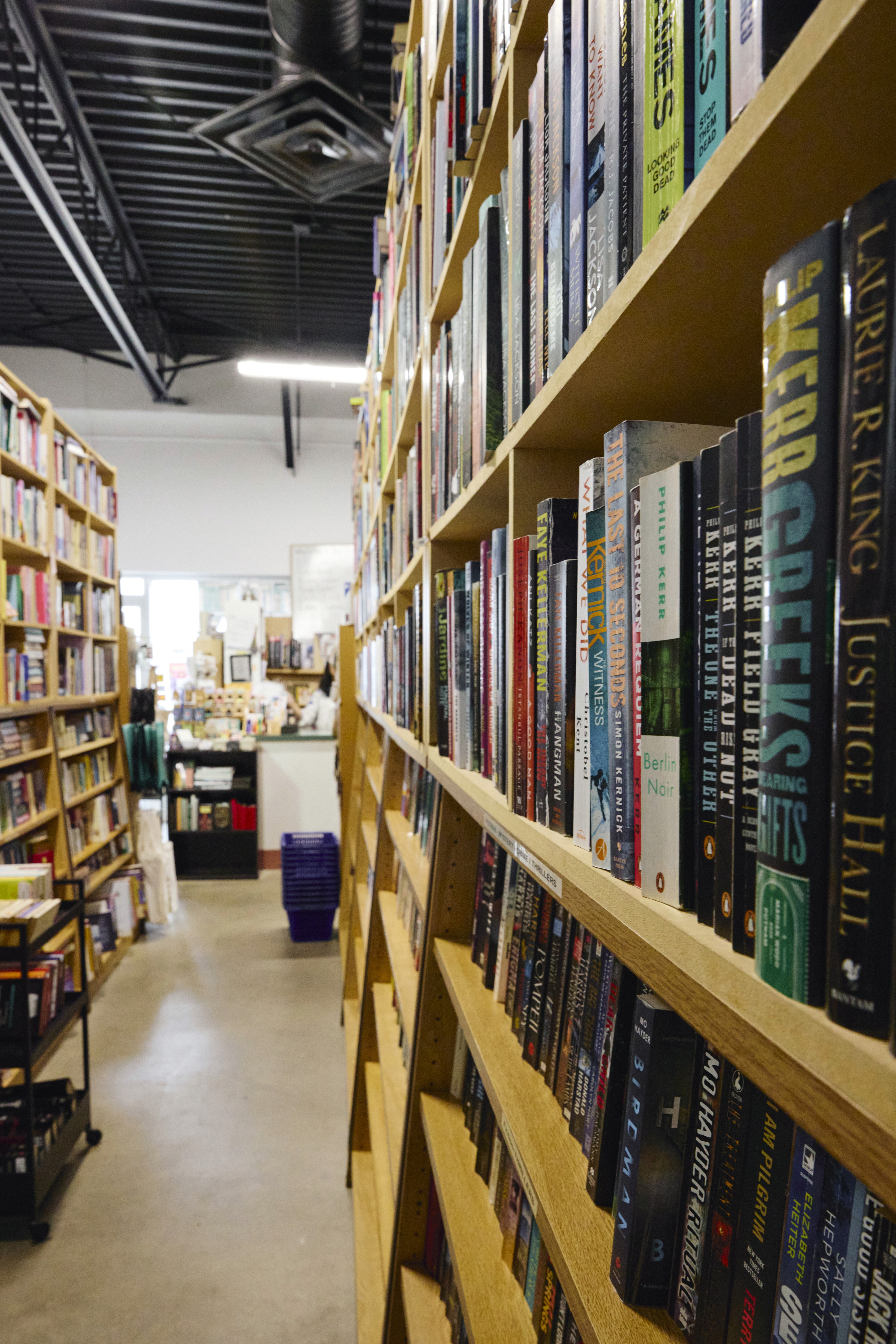 Two black dumbbells and a black jump rope lying on a red, rubberized running track surface.