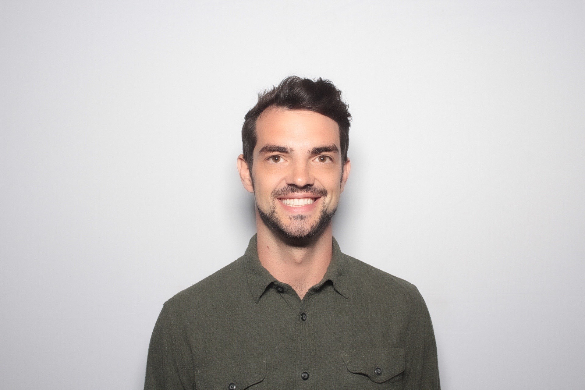 Profile portrait of a man in a white shirt against a light background