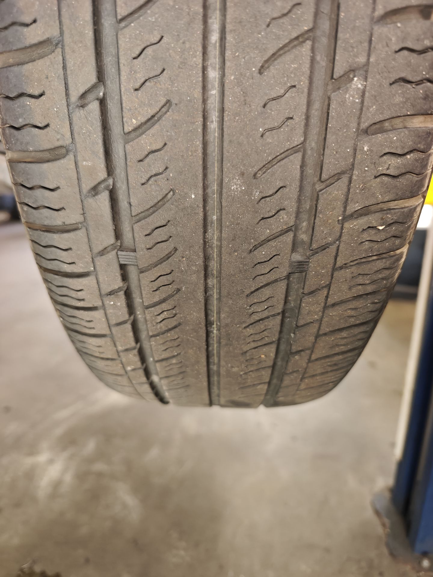 One of the Miata’s 2013 tires on the lift, tread worn low