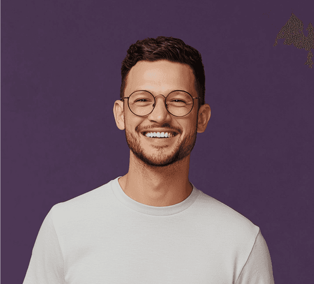 A smiling man wearing glasses is featured in a portrait set against a purple backdrop.