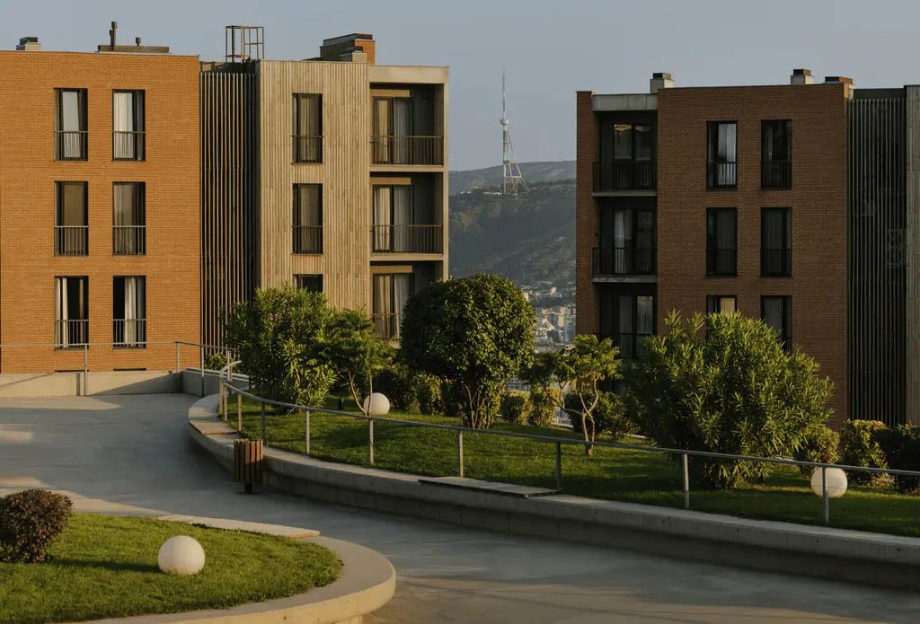 Contemporary apartment buildings with green courtyard and distant TV tower view