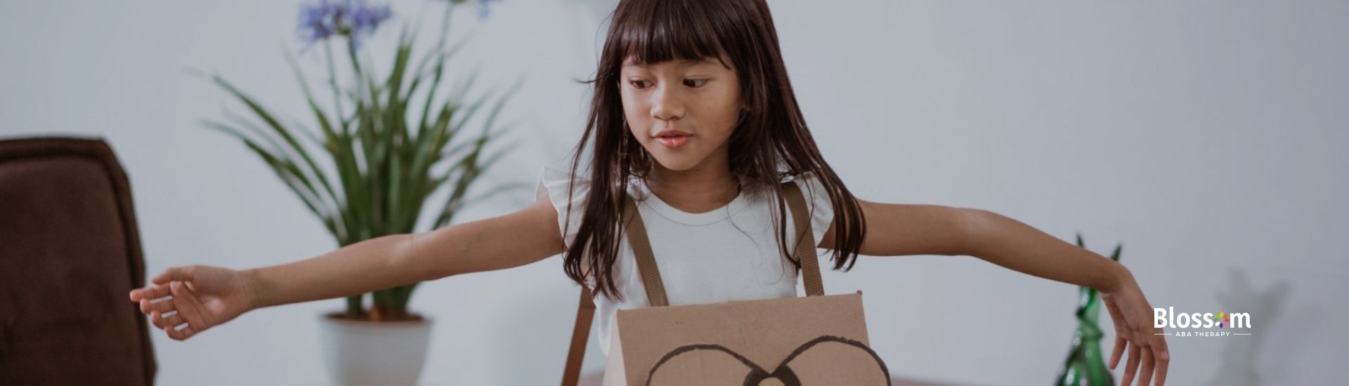 A neurodivergent girl wearing a cardboard costume.