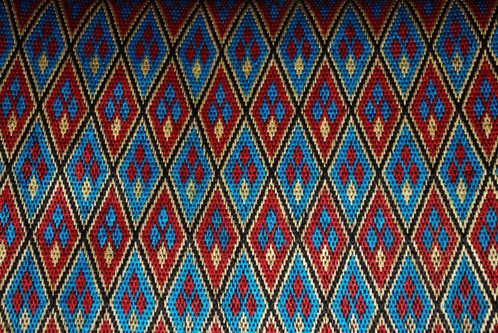 Close-up of Hazara, a traditional Afghan embroidery style, showcasing a pattern of diamonds within diamonds and lines.
