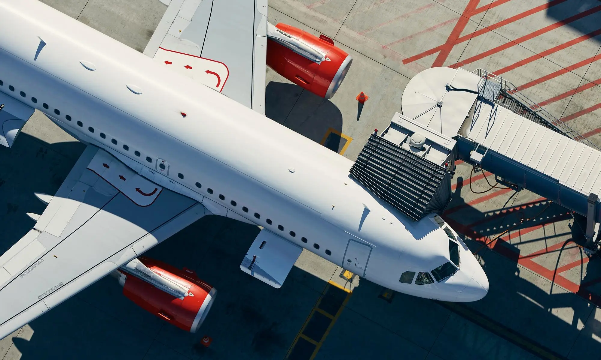 Aerial view of an airplane docked at an airport jet bridge