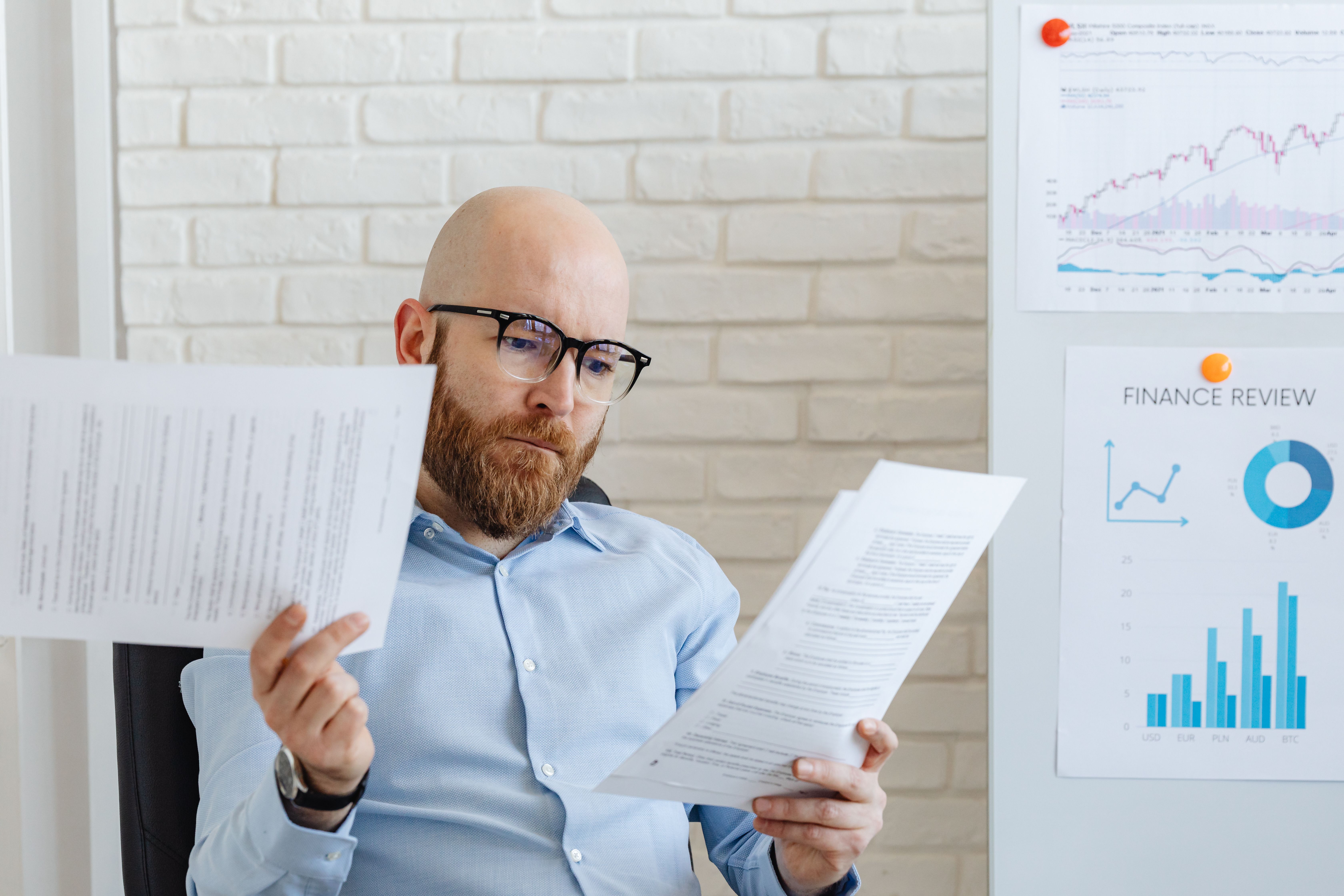 bald-bearded-businessman-reading-financial-documents-in-modern-office-setting. - www.kaboompics.com (pexels)