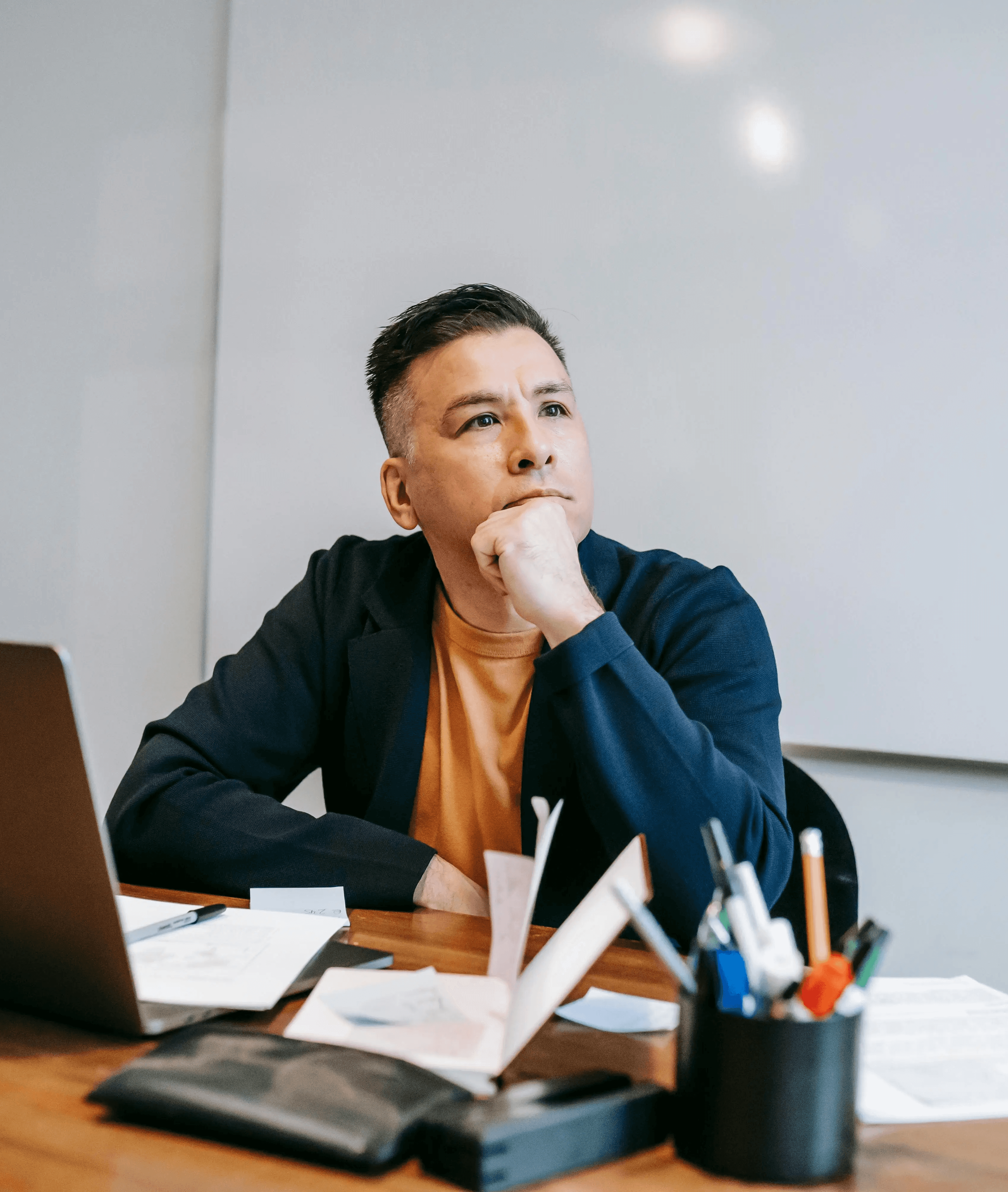 Mid-career professional reflecting on his job search strategy at his desk