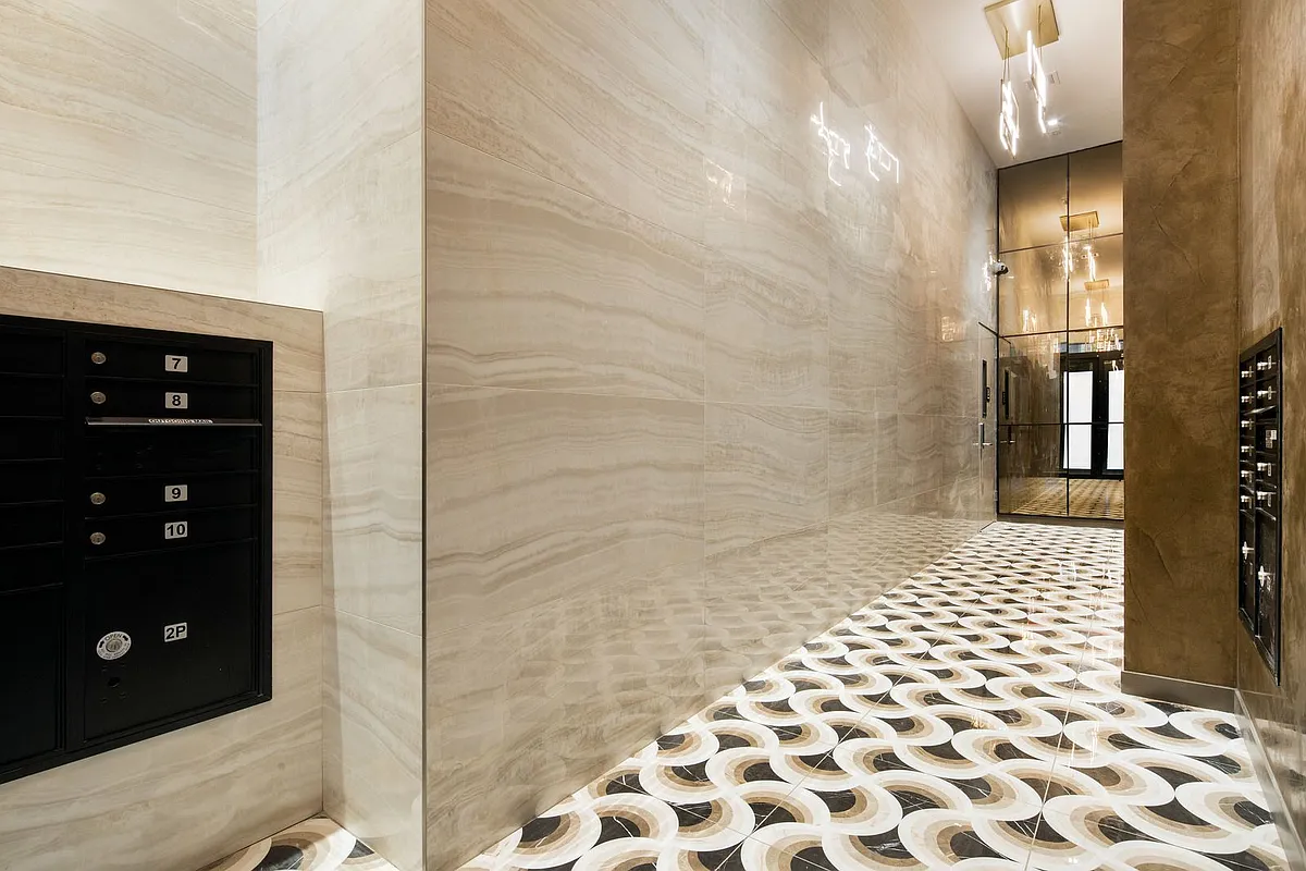 A hallway featuring a polished marble floor with alternating black and white tiles, creating a striking geometric pattern.