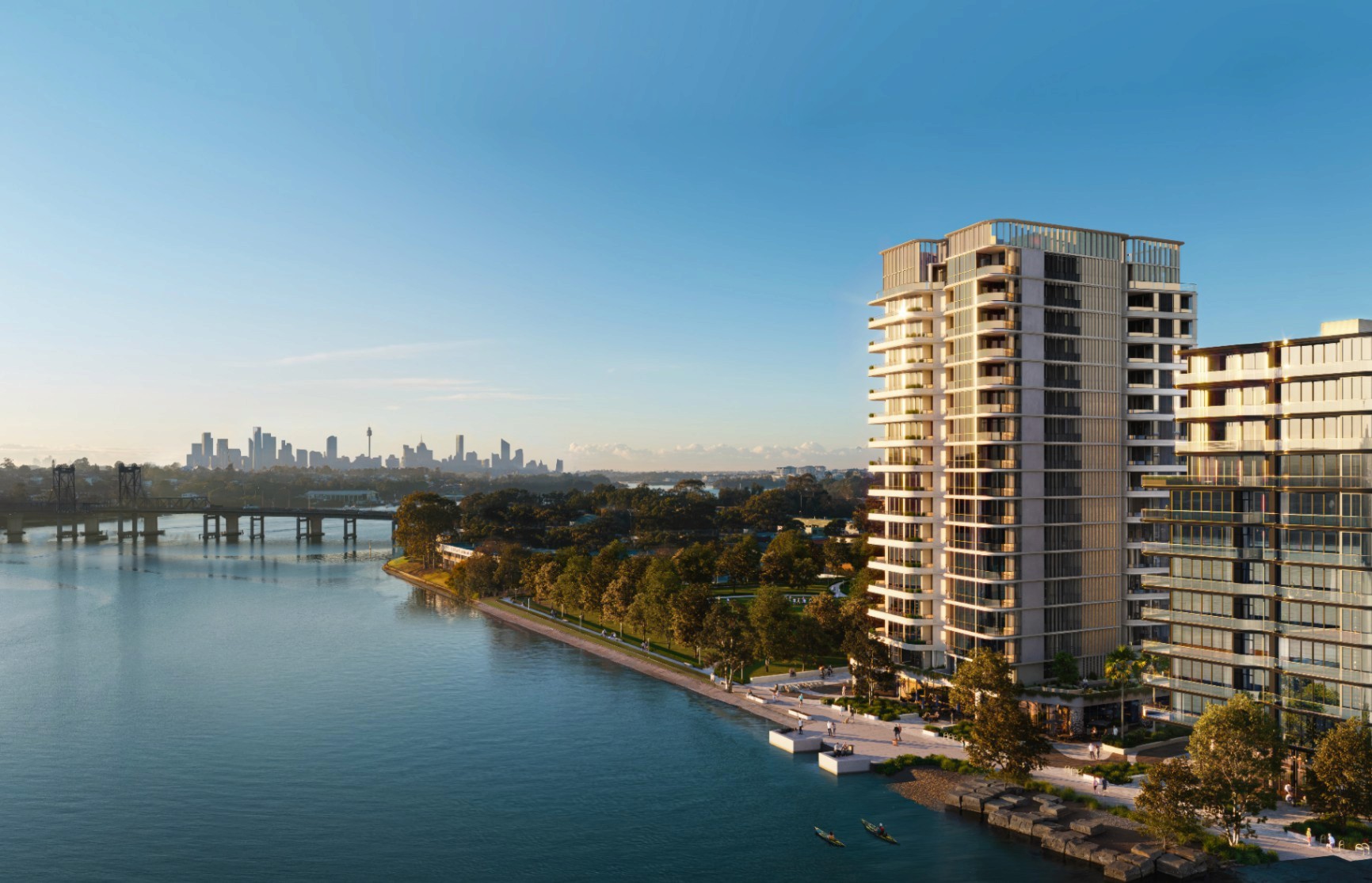 Aerial view of Rhodes Bay showcasing absolute waterfront positioning, surrounding parklands, and Sydney CBD skyline in the background.