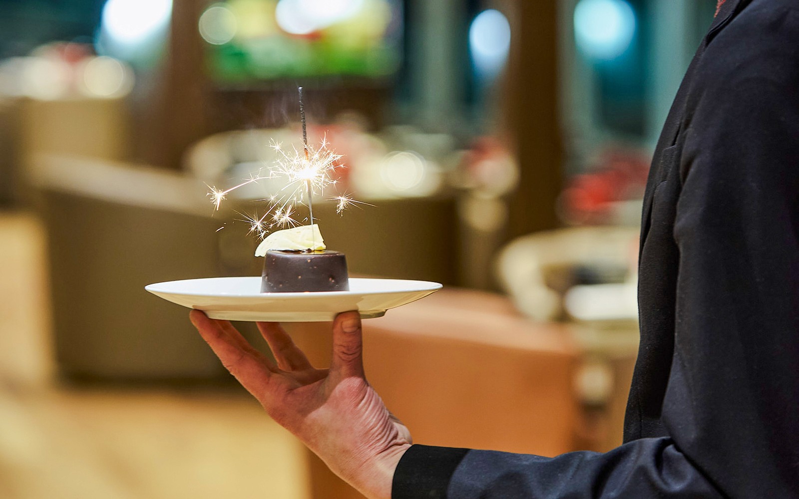 服务员在塞纳河上的巴黎舞台晚宴巡游中提供带烟花的甜点。