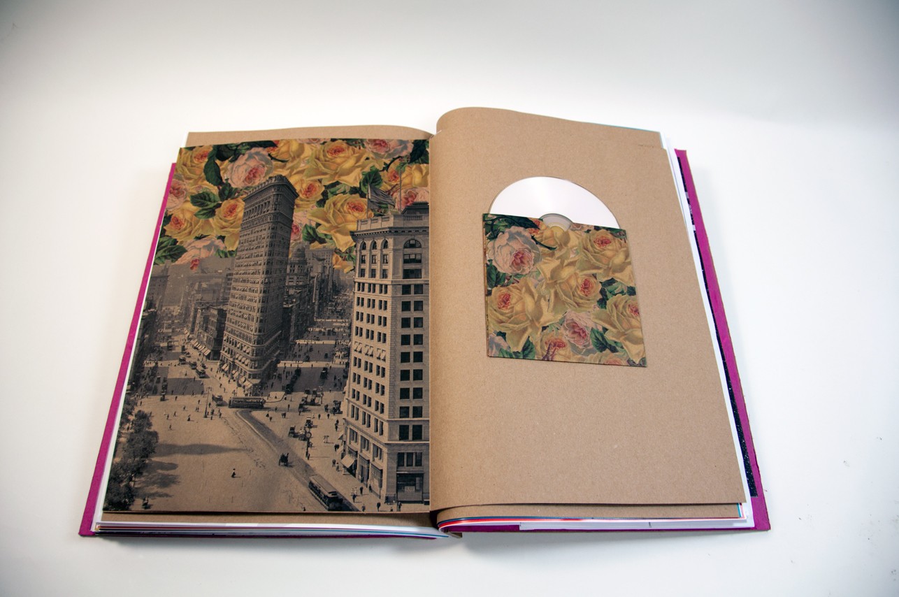 an opened book with an illustration of buildings