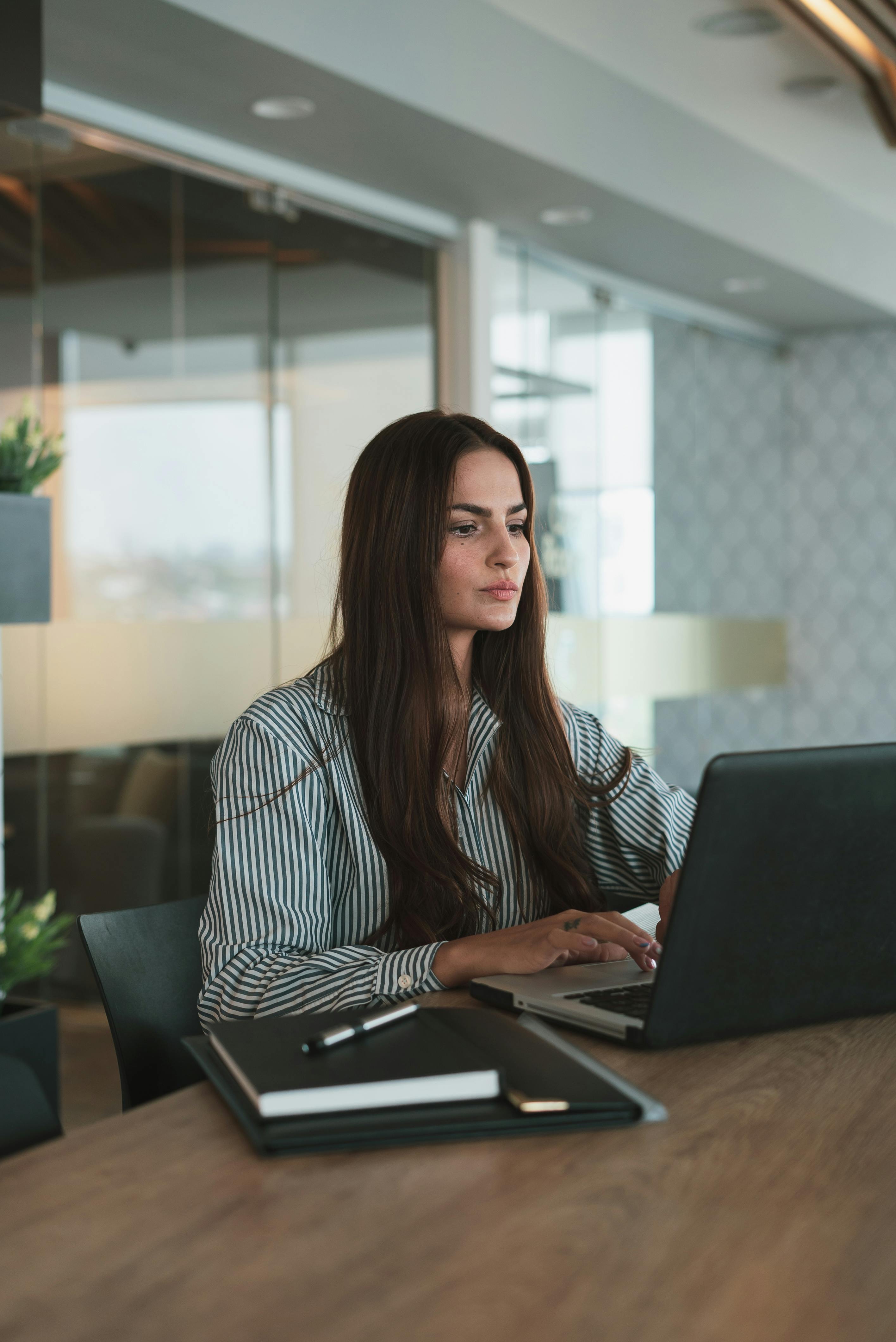 Donna concentrata al computer durante una lezione online o sessione di coaching, rappresentazione del modello formativo digitale e personalizzato di Course Clear.