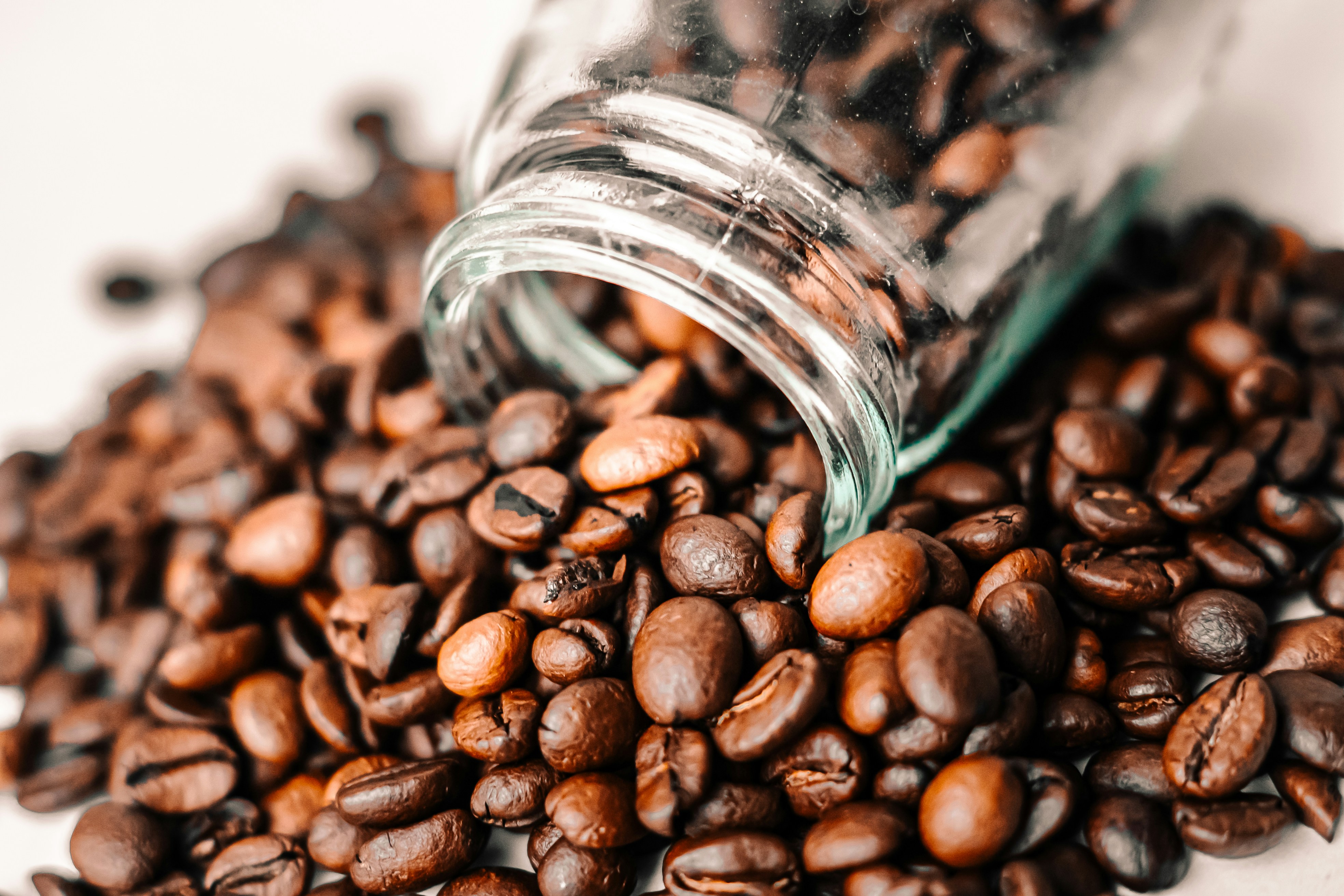 Close-up of fresh coffee beans spilt on a surface.