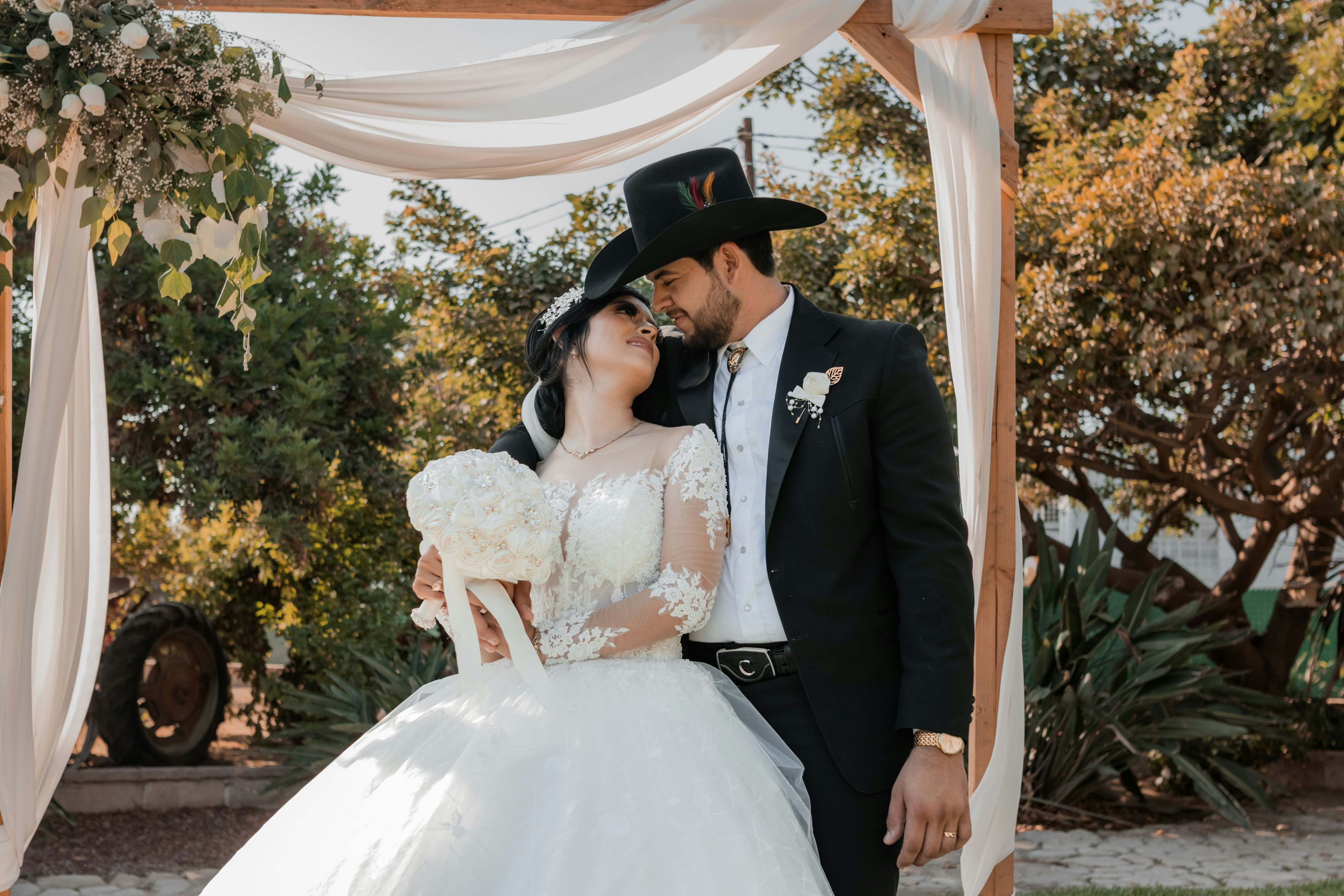 A bride and groom kissing under a wedding arch