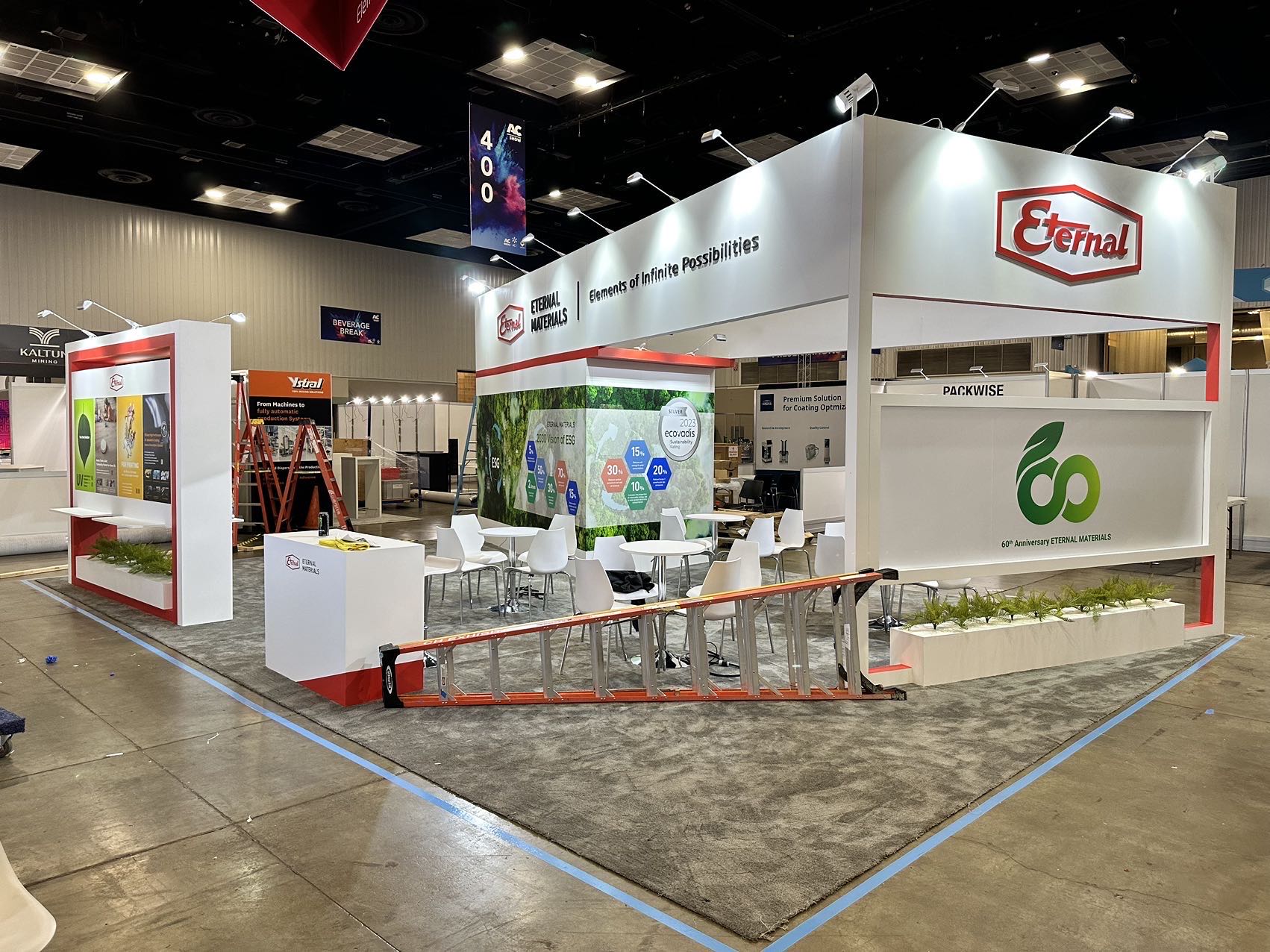 Building materials and coatings trade show booth with sample displays, product graphics, meeting space, and open visitor layout