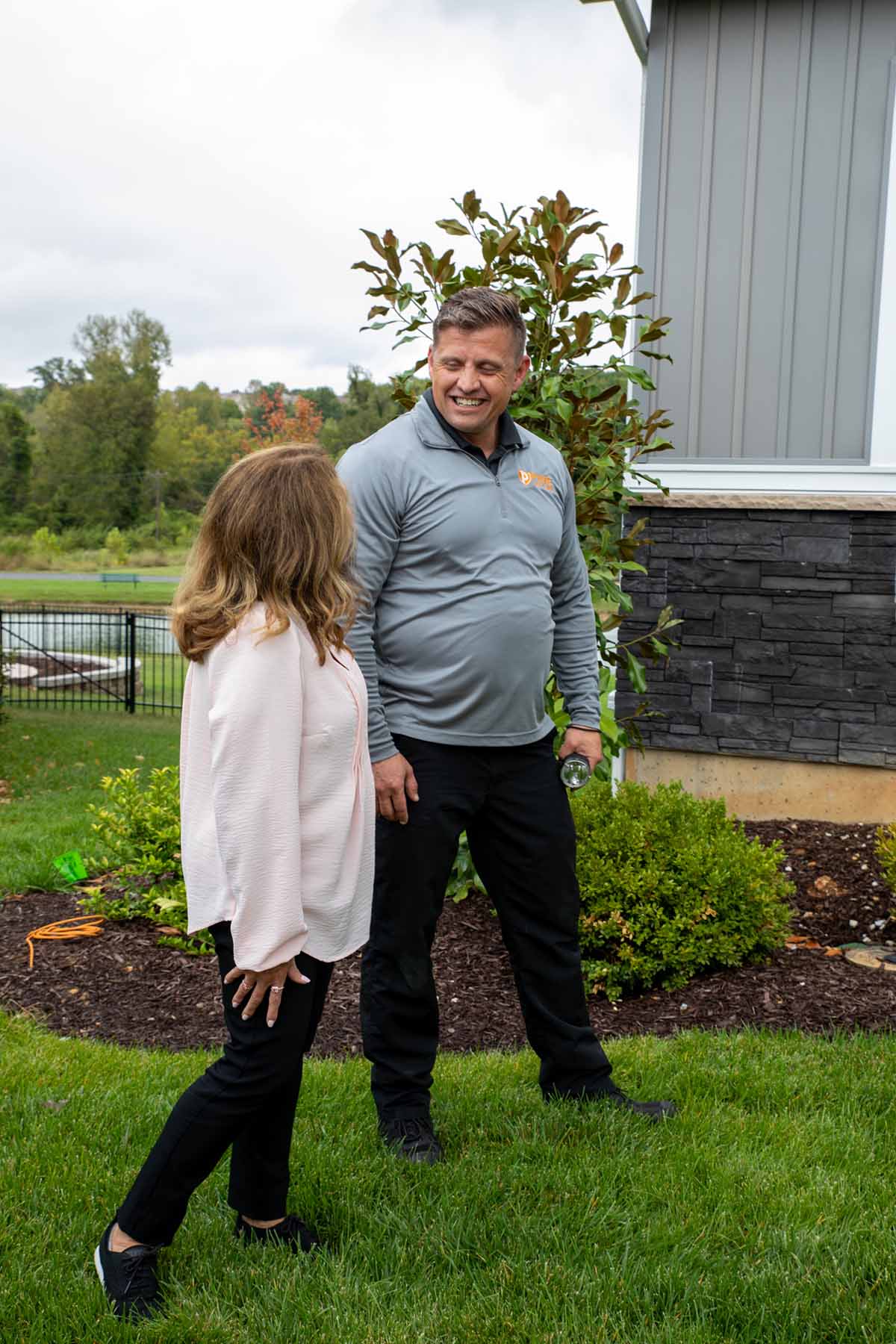 Photo of a Pure Pest + Lawn expert walking with a home owner