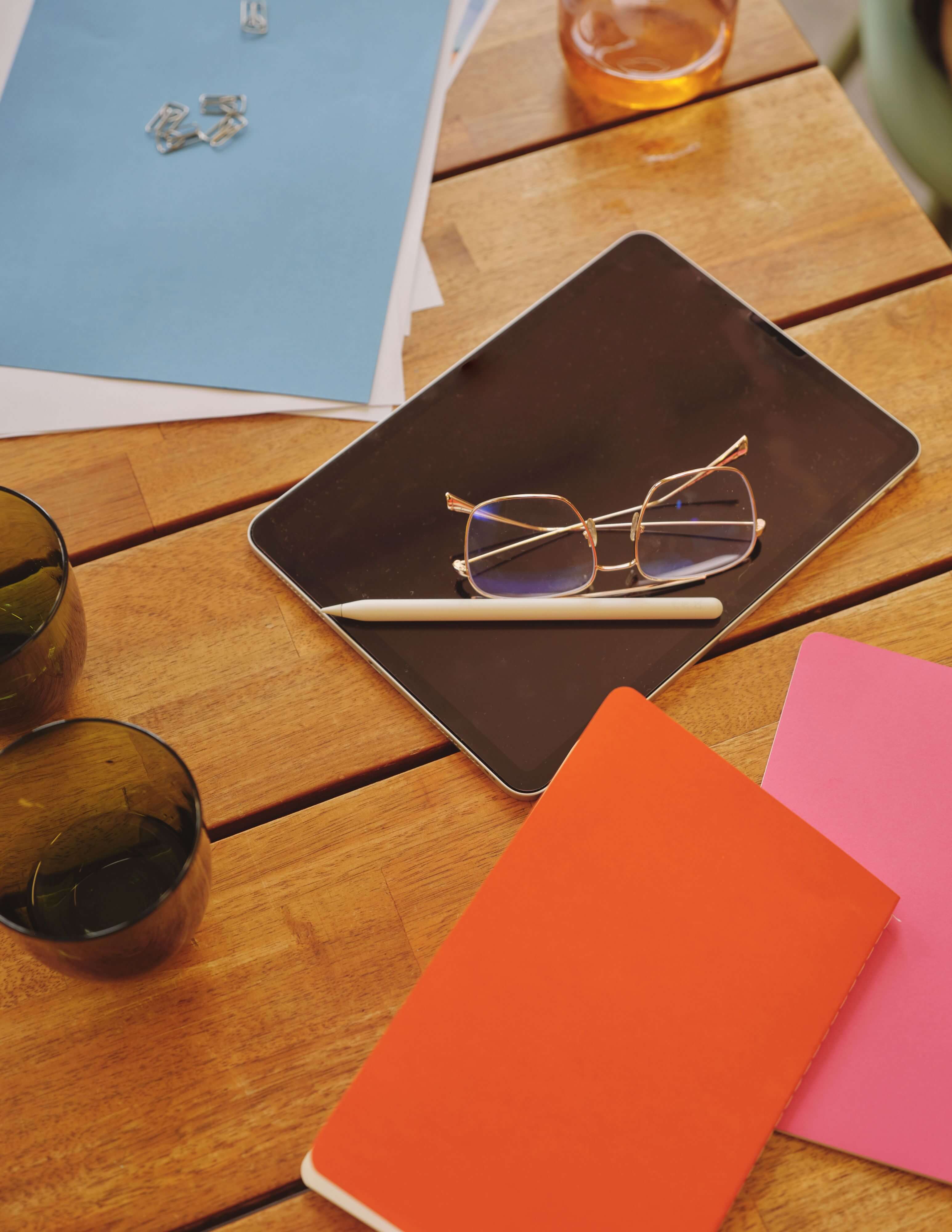 an ipad and notebooks on the table