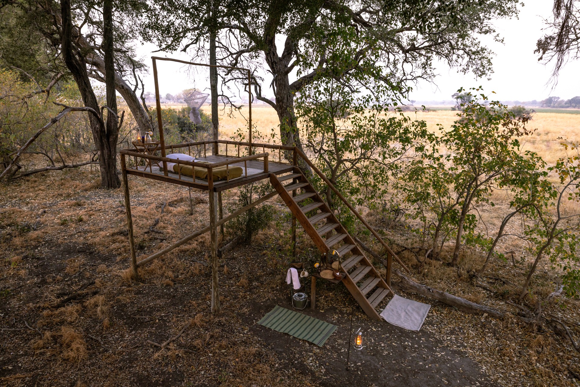 Kujwana Delta Ride, Okavango Delta, Botswana – ridsemester med sängar på upphöjda plattformar under bar stjärnhimmel. Myggnät omger plattformarna och en trappa leder upp till sovplatsen.